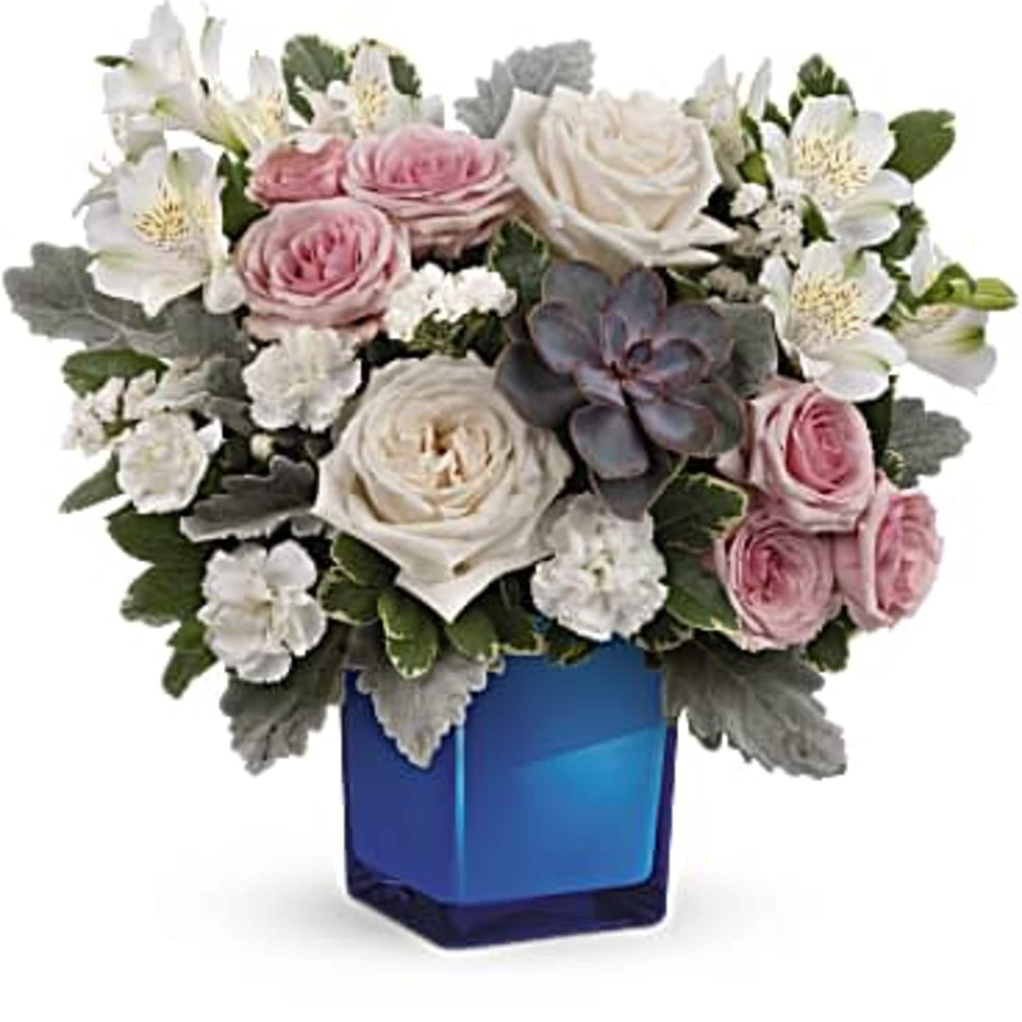 Pink and white roses in a blue glass vase with white blooms