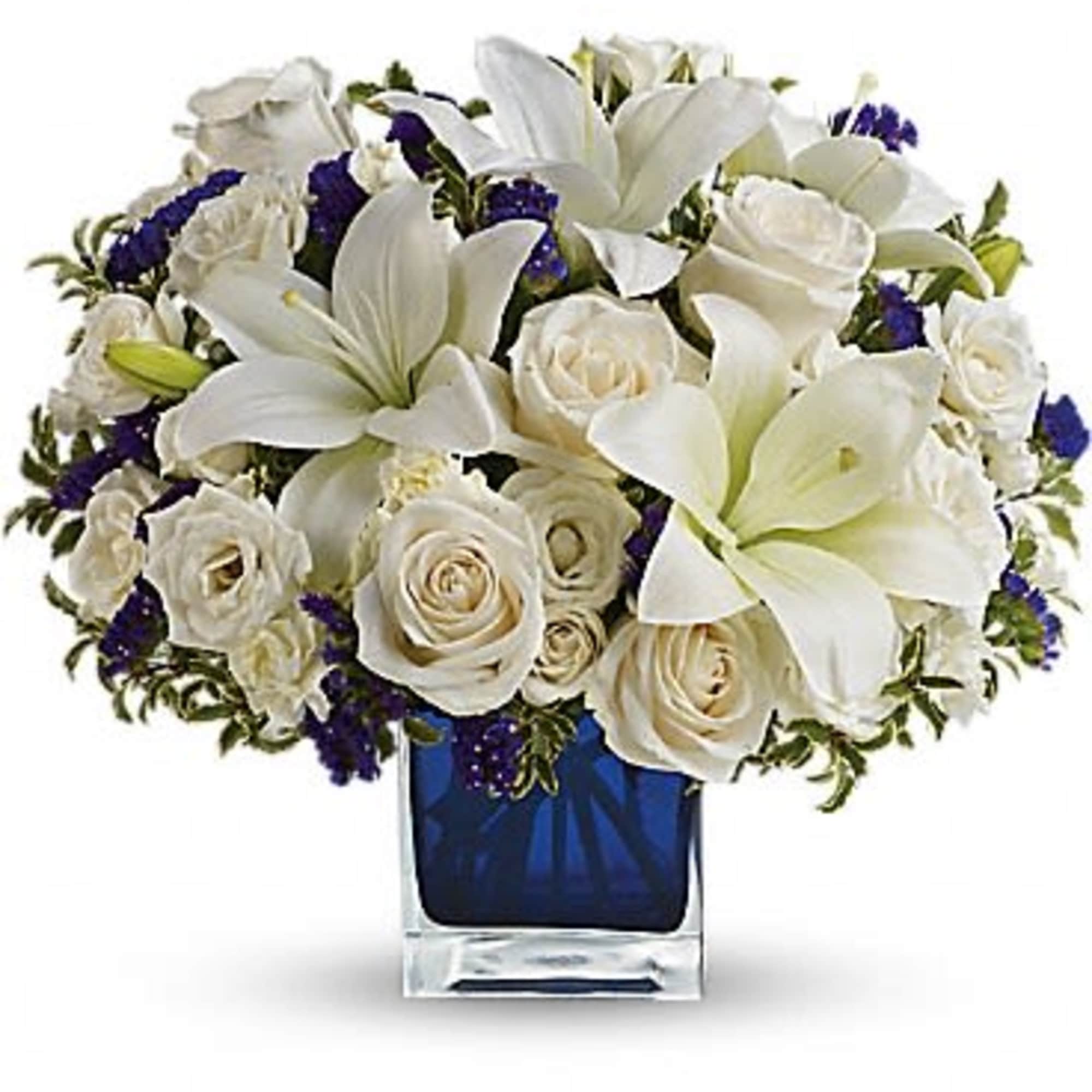 White lilies and roses arranged in a blue glass vase