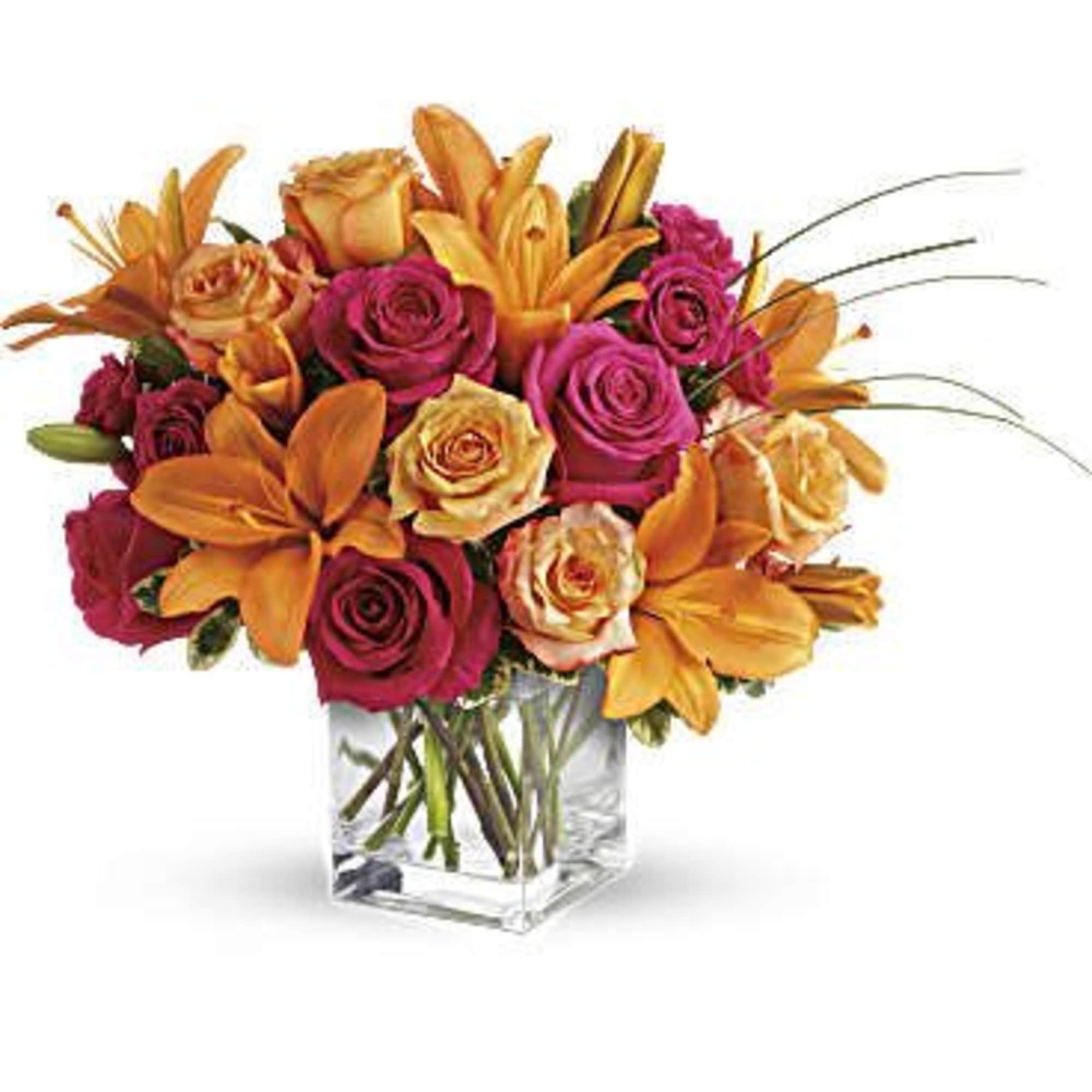 Bouquet of orange lilies and pink roses in a clear glass vase