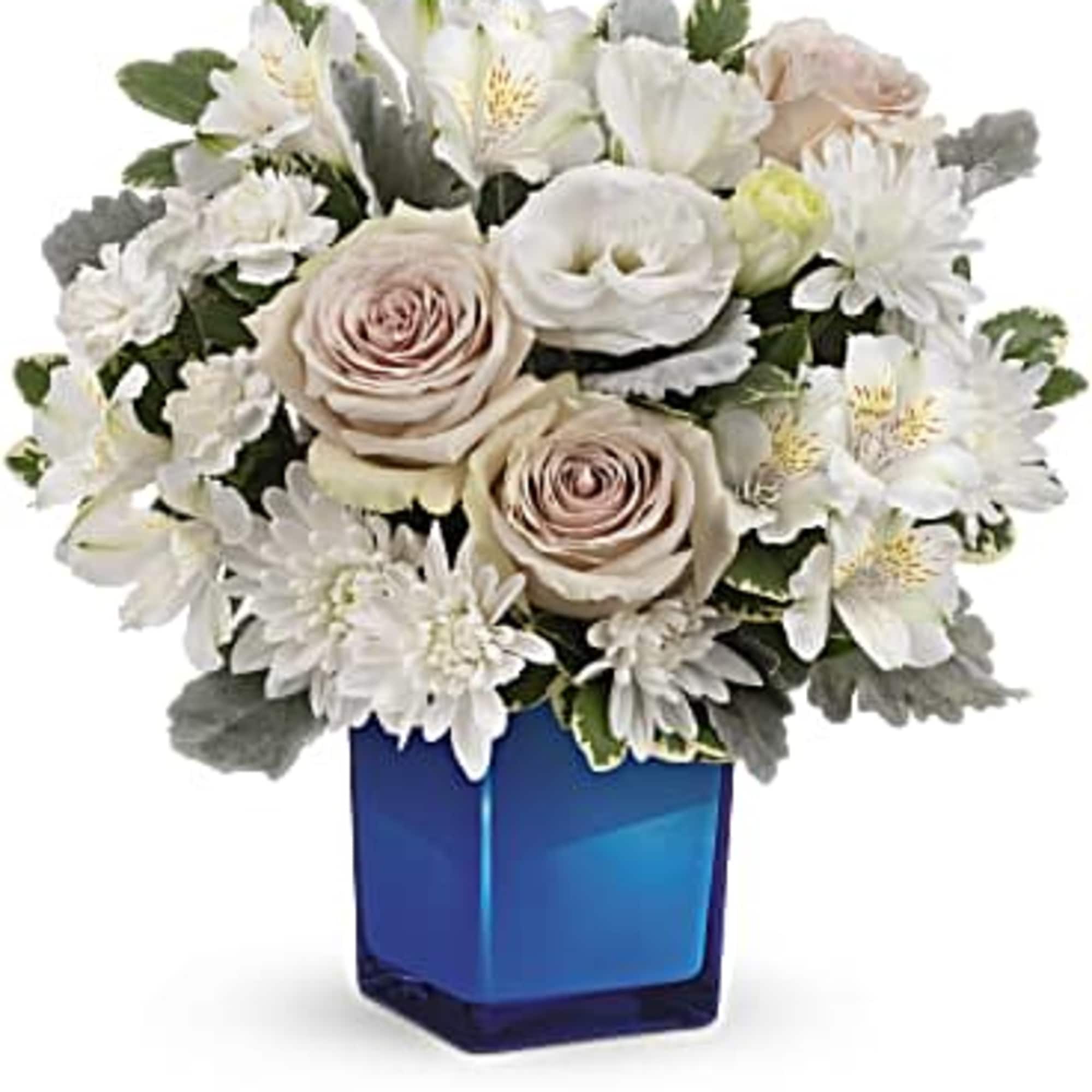 White and blush bouquet in a blue glass vase