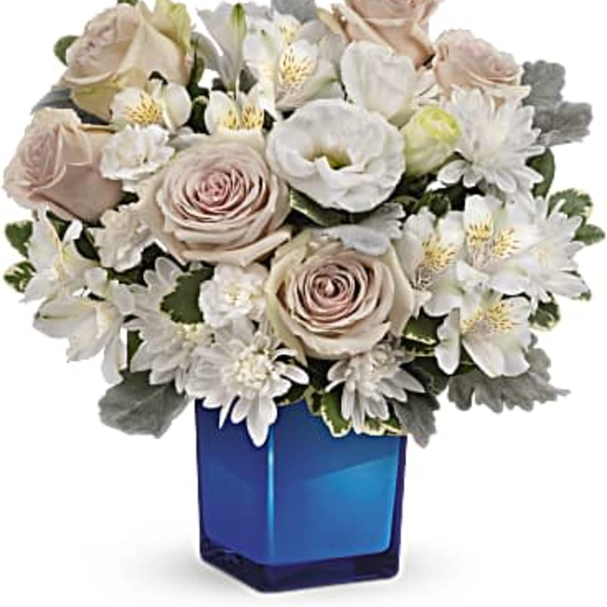 Bouquet of pale roses and white flowers in a blue glass vase