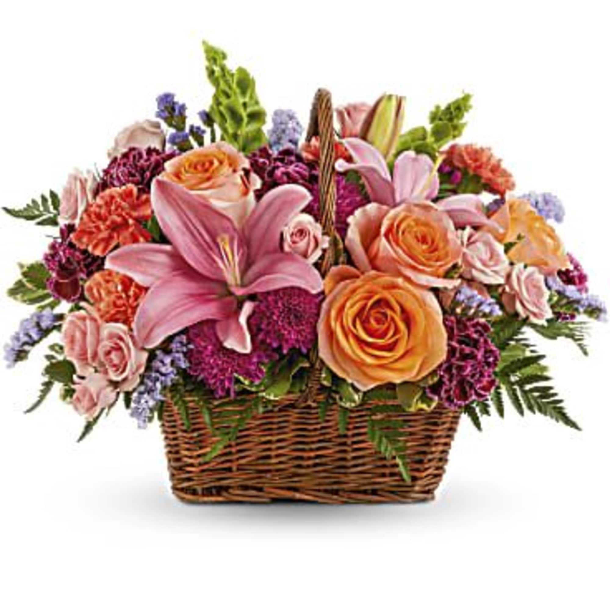 Basket of pink lilies and peach roses with purple filler flowers