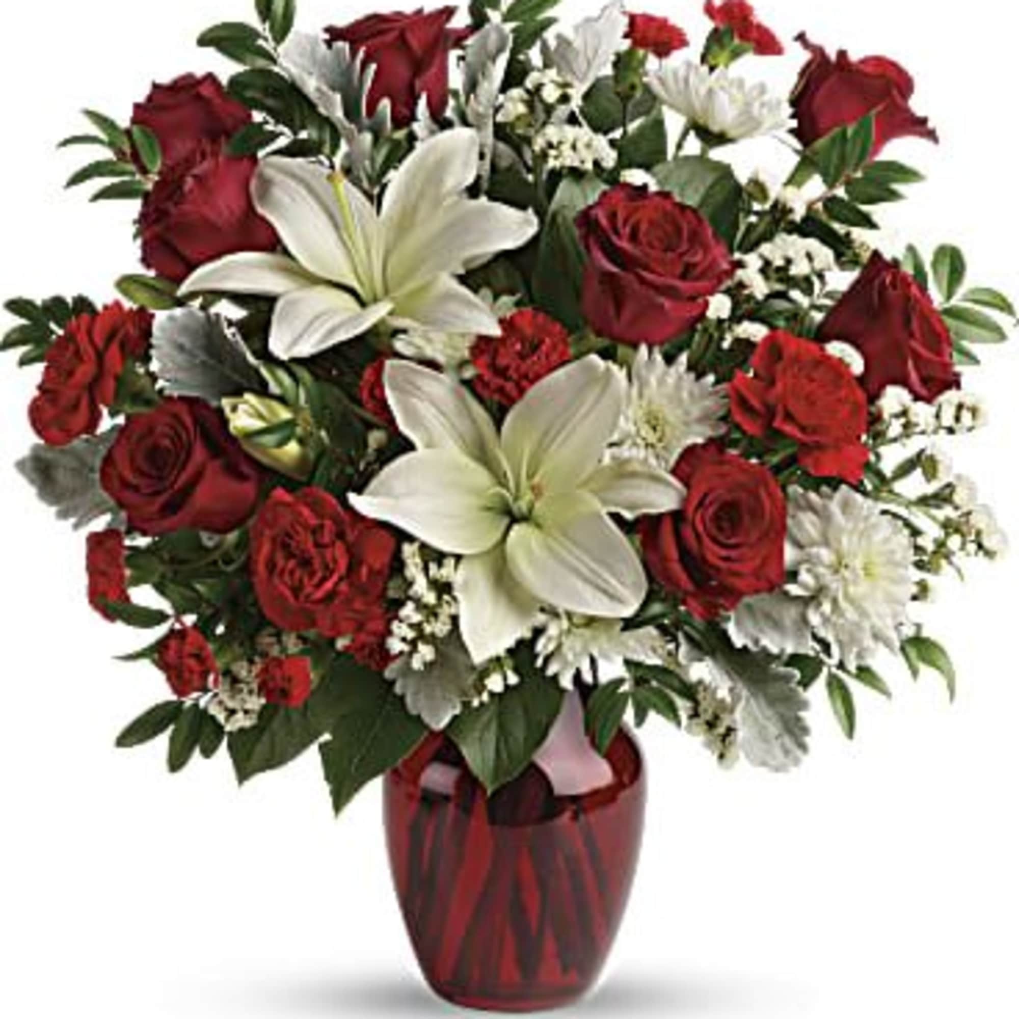Red roses and white lilies in a red glass vase