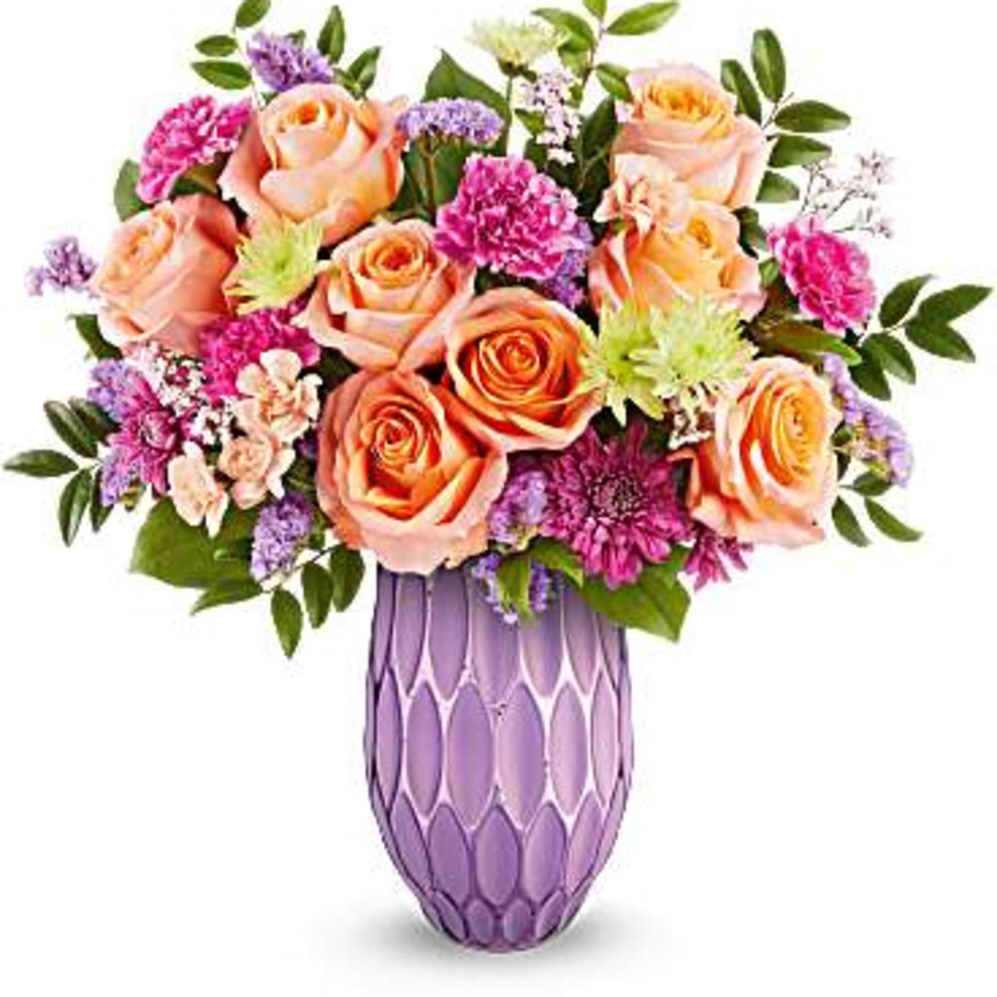 Peach roses and purple flowers arranged in a lavender vase