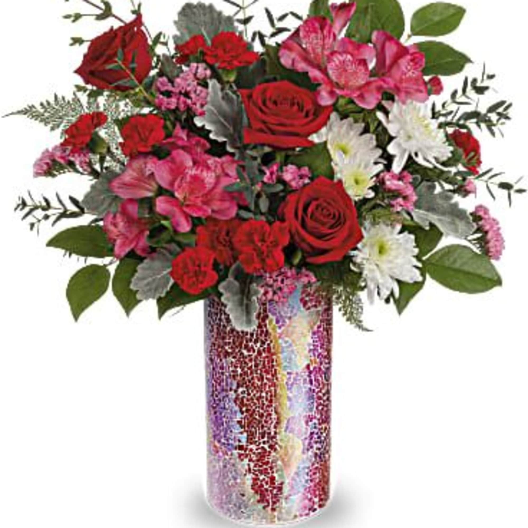 Red and pink mixed flower arrangement in a mosaic glass vase