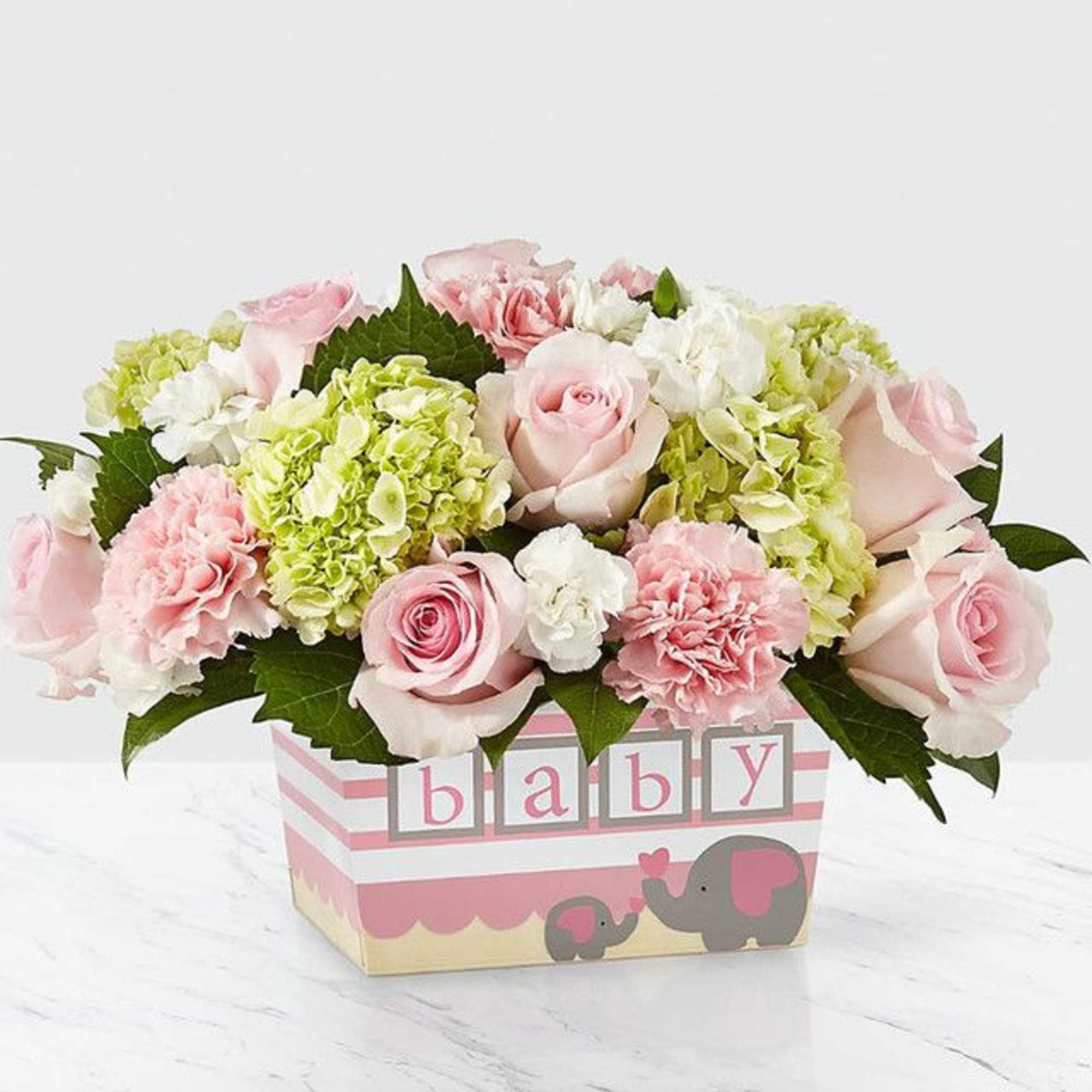 Pink roses and soft carnations mingle with white blooms and lreen mini