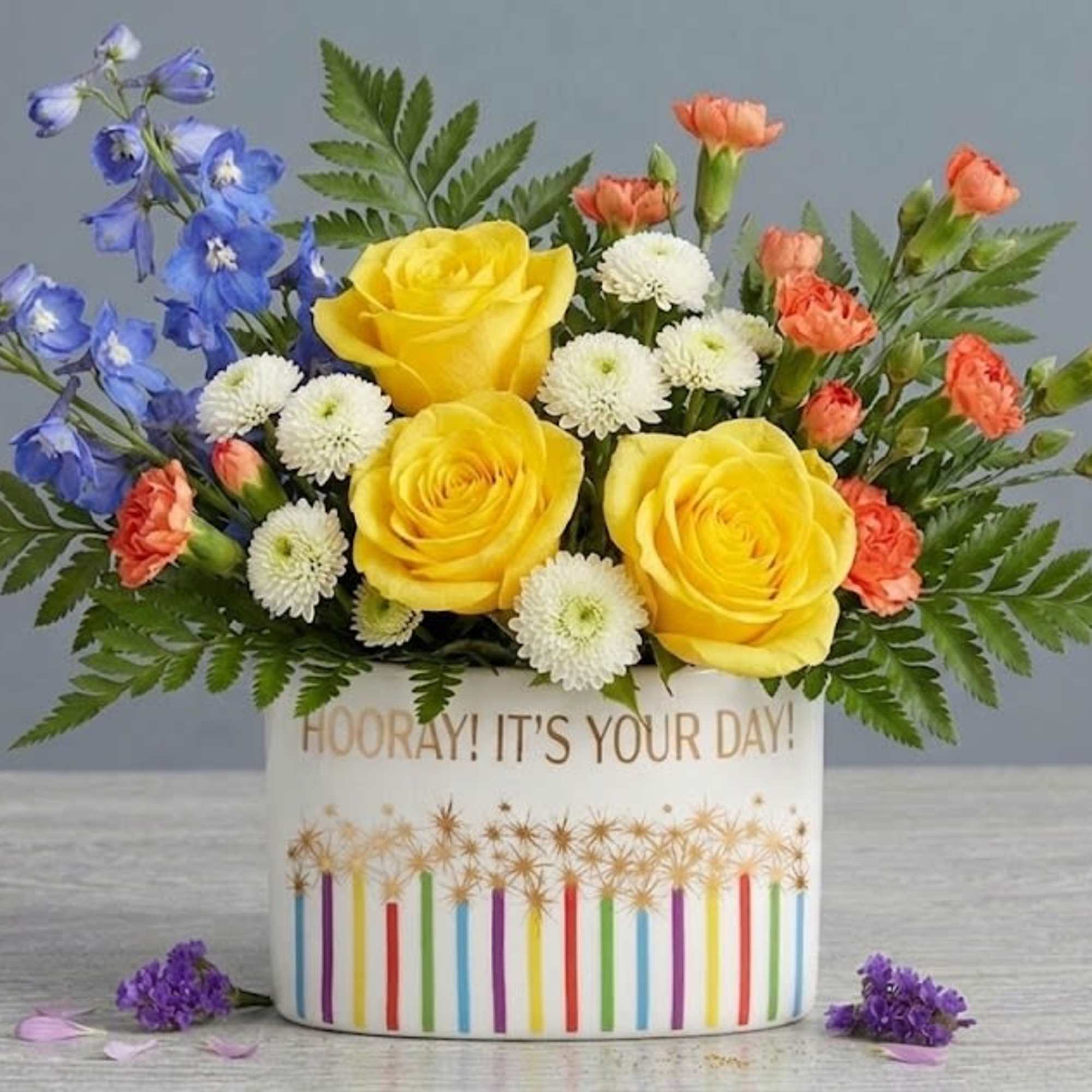 Sunny yellow roses take center stage in this cheerful flower arrangement, a