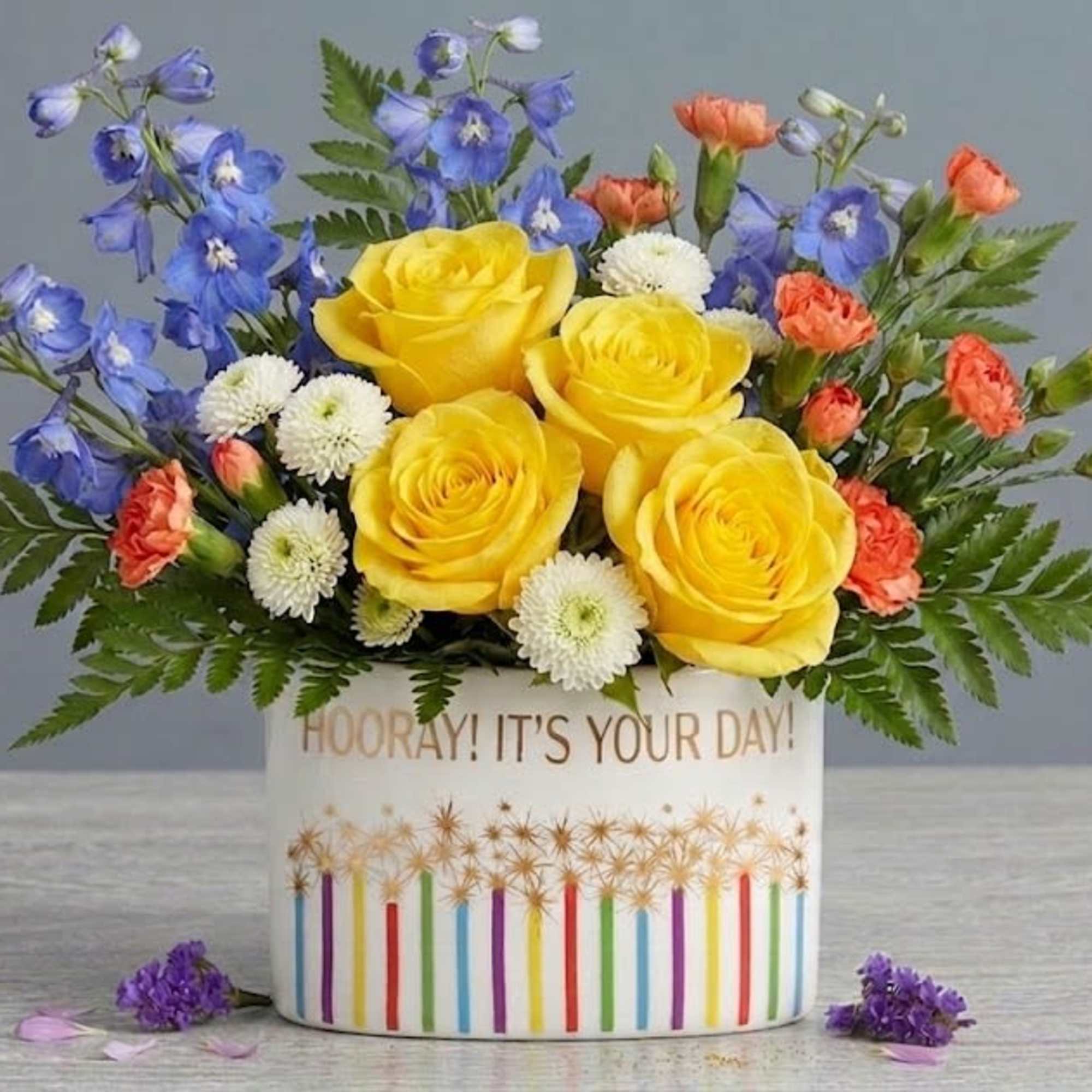 Sunny yellow roses take center stage in this cheerful flower arrangement, a