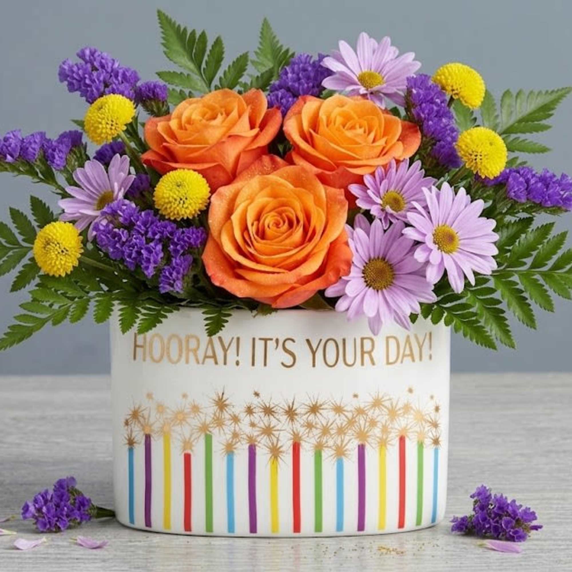 Orange roses crown this Citrus and Spice flower arrangement, making an instant