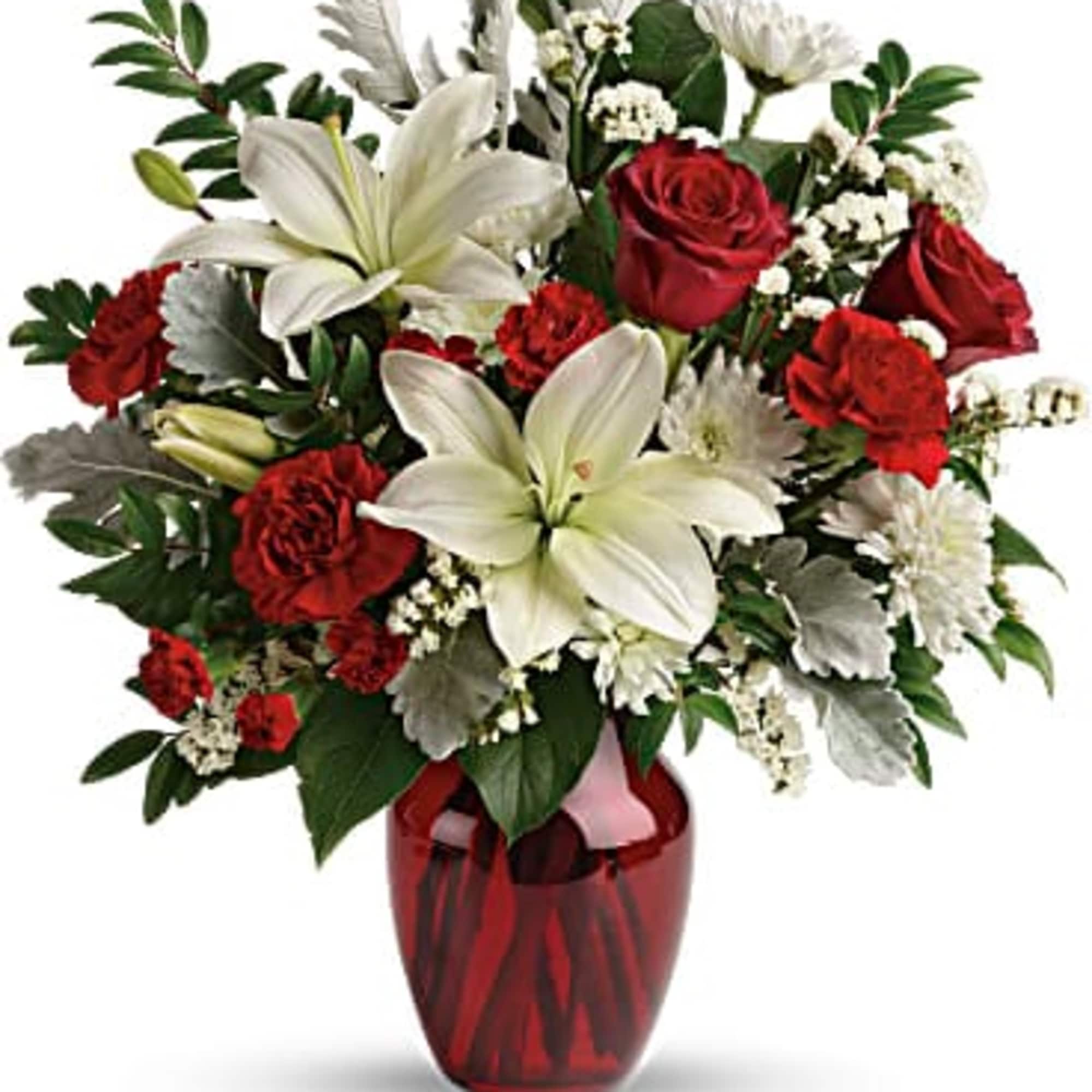 Bouquet of red roses and white lilies in a red glass vase