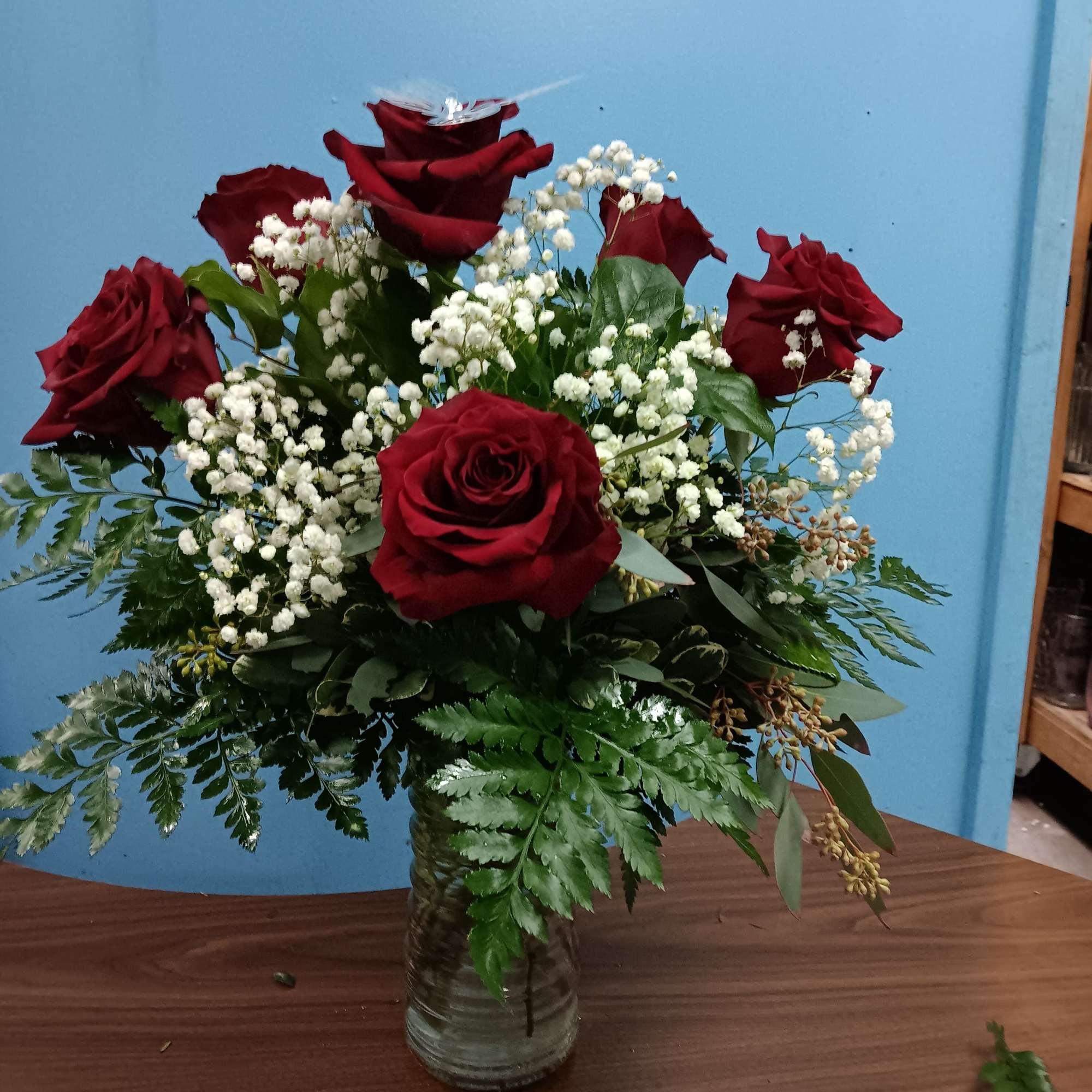 Red roses and white baby's breath in a clear glass vase
