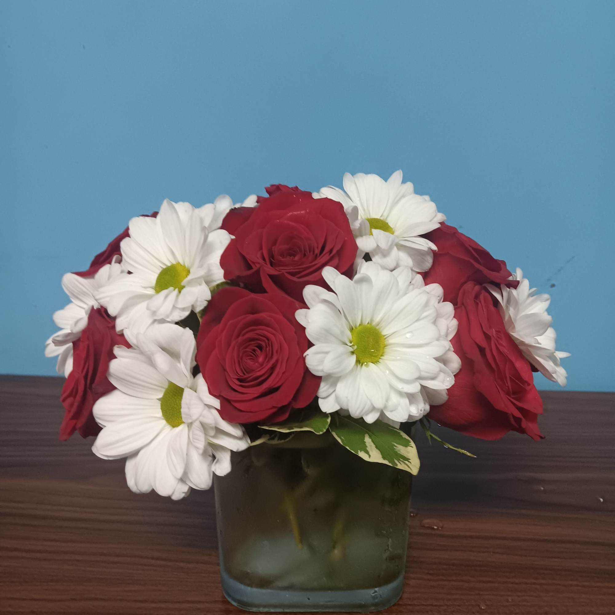 This arrangement contains spray daisies and spray roses. This is a great