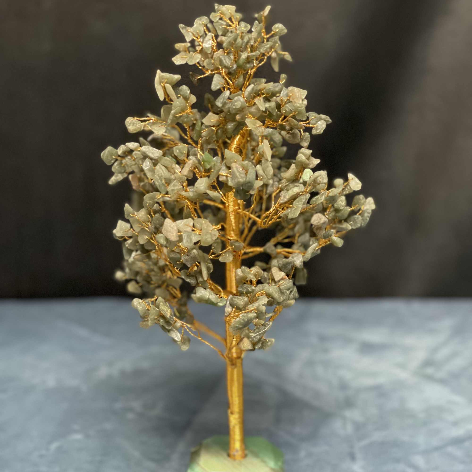 Gemstone tree sculpture with gold wire branches on a green stone base