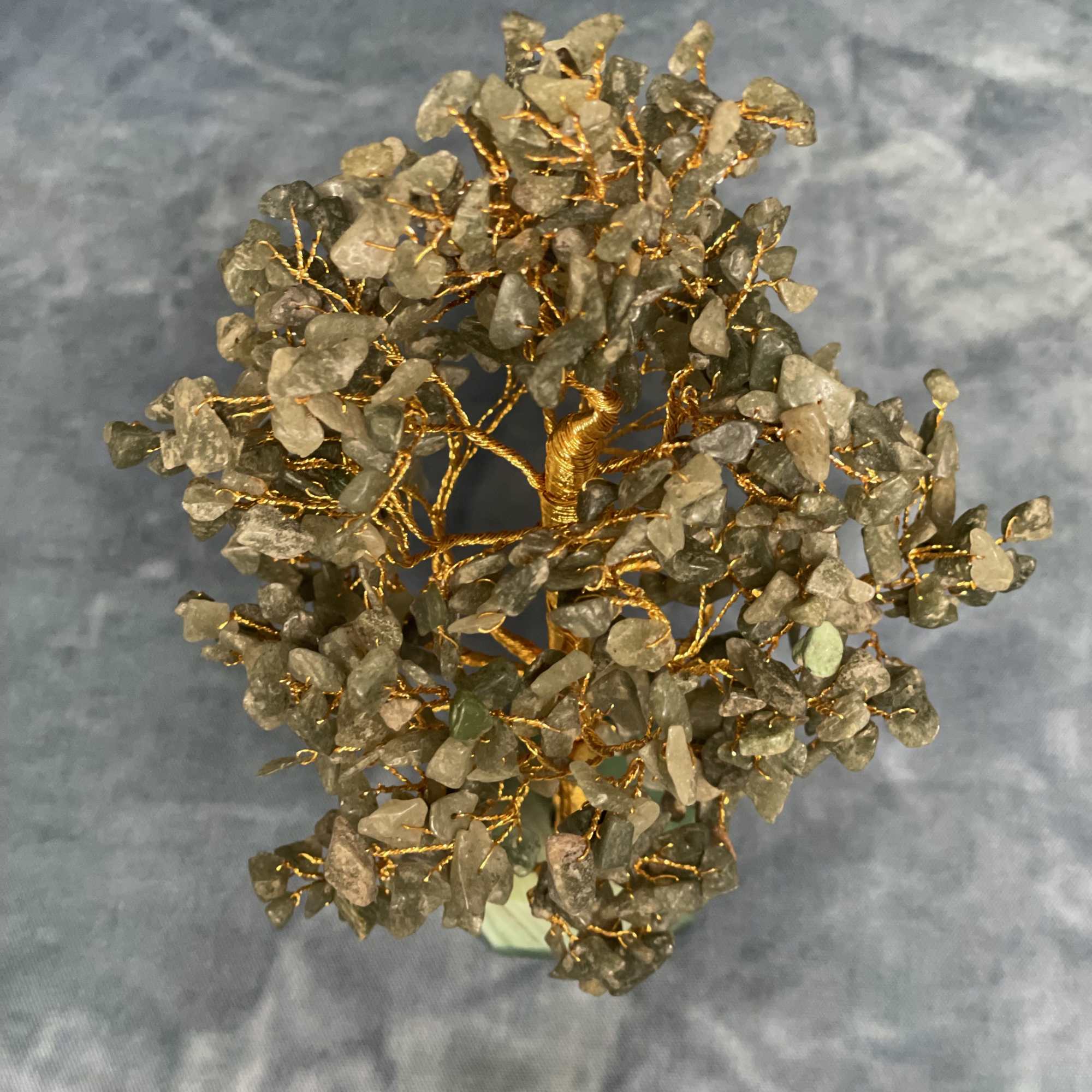 Decorative tree sculpture with green stone chips and gold wire on a small base