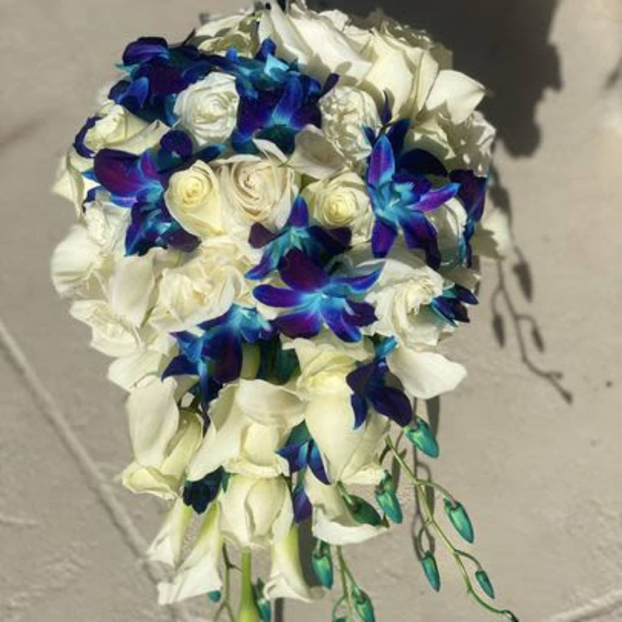 White rose bouquet with blue-purple accent flowers