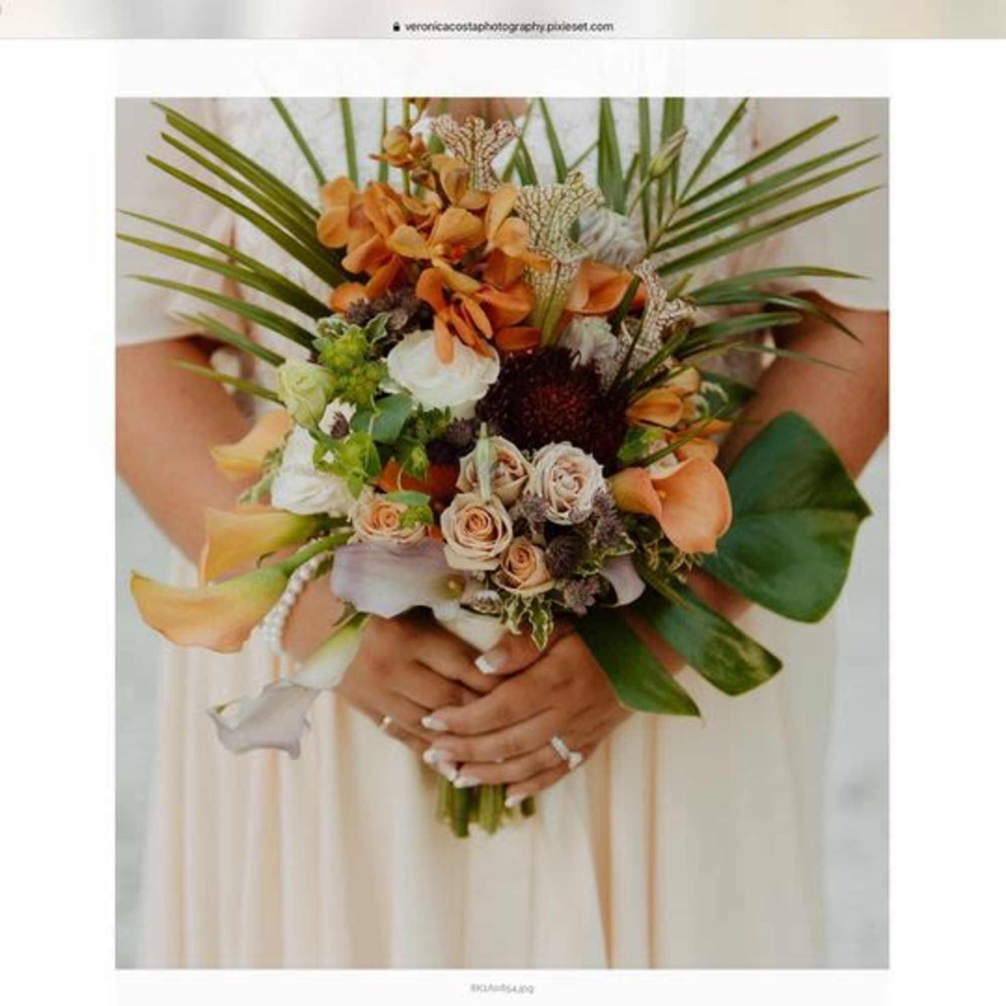 Bridal bouquet with peach roses, orange orchids, and white calla lilies