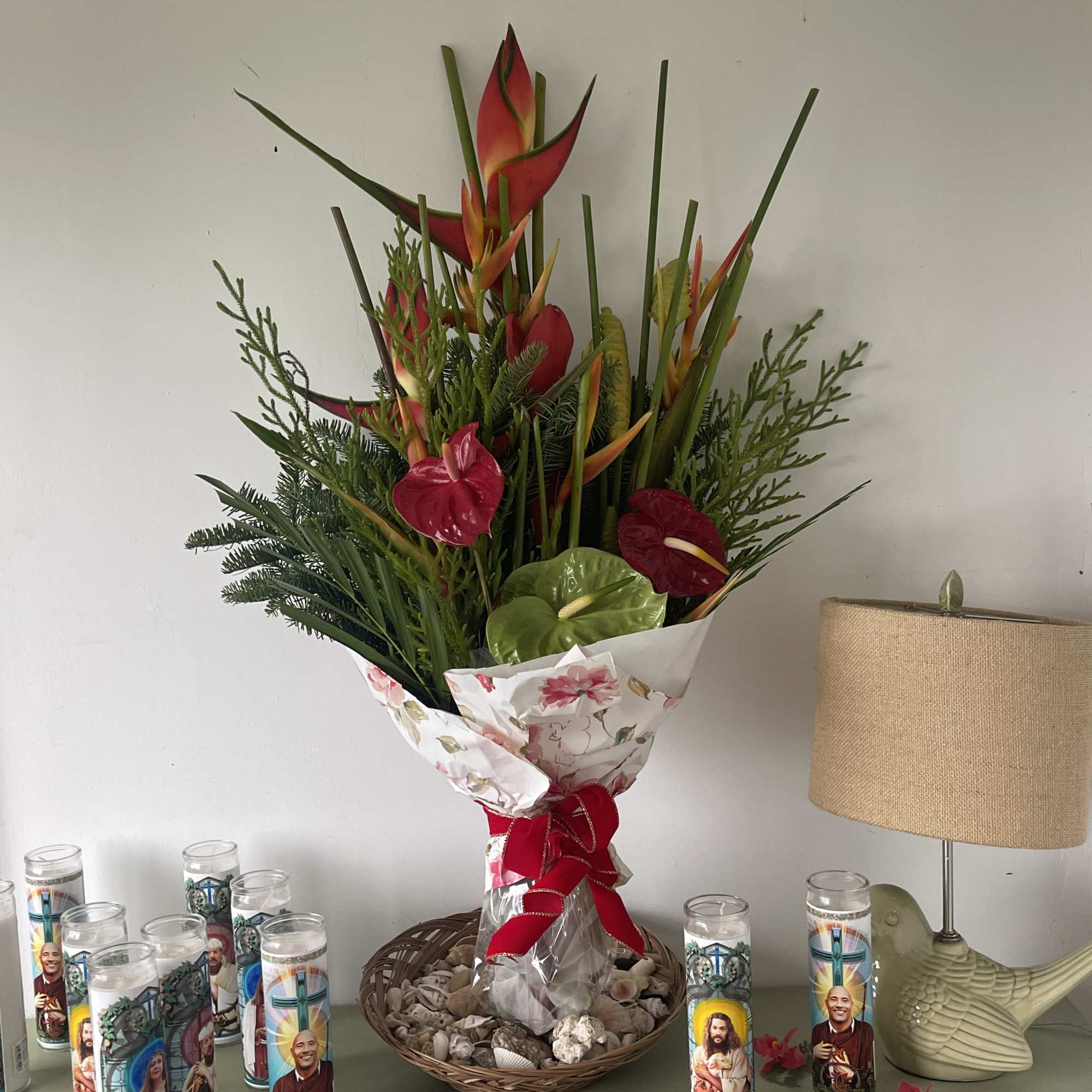 Tropical bouquet with red heliconia and anthuriums in floral wrap