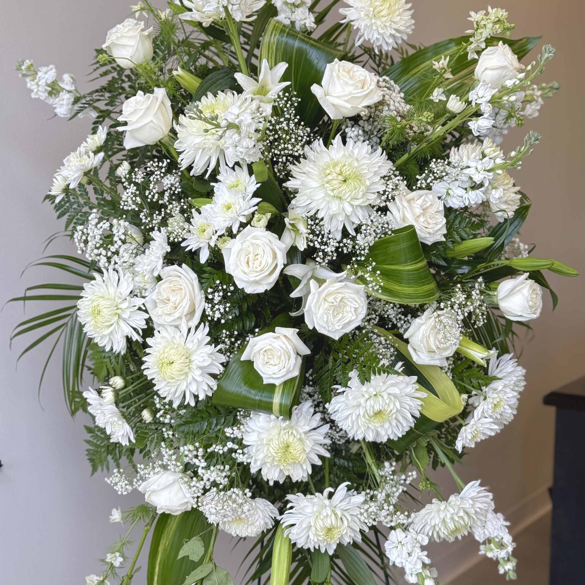 Large white floral standing spray with roses and chrysanthemums