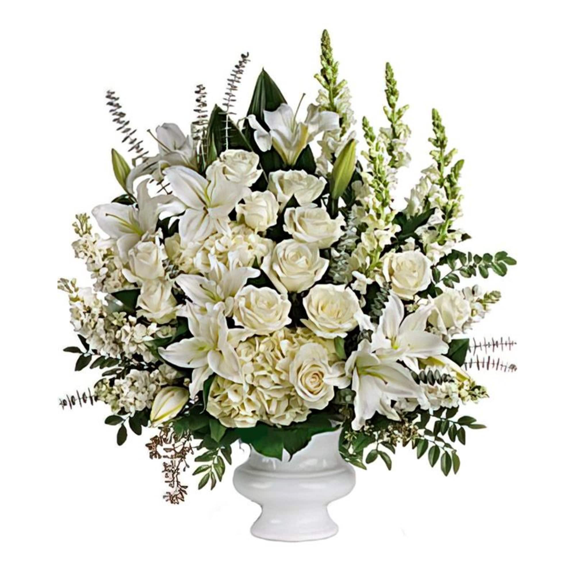White lilies and roses arranged in a white pedestal vase