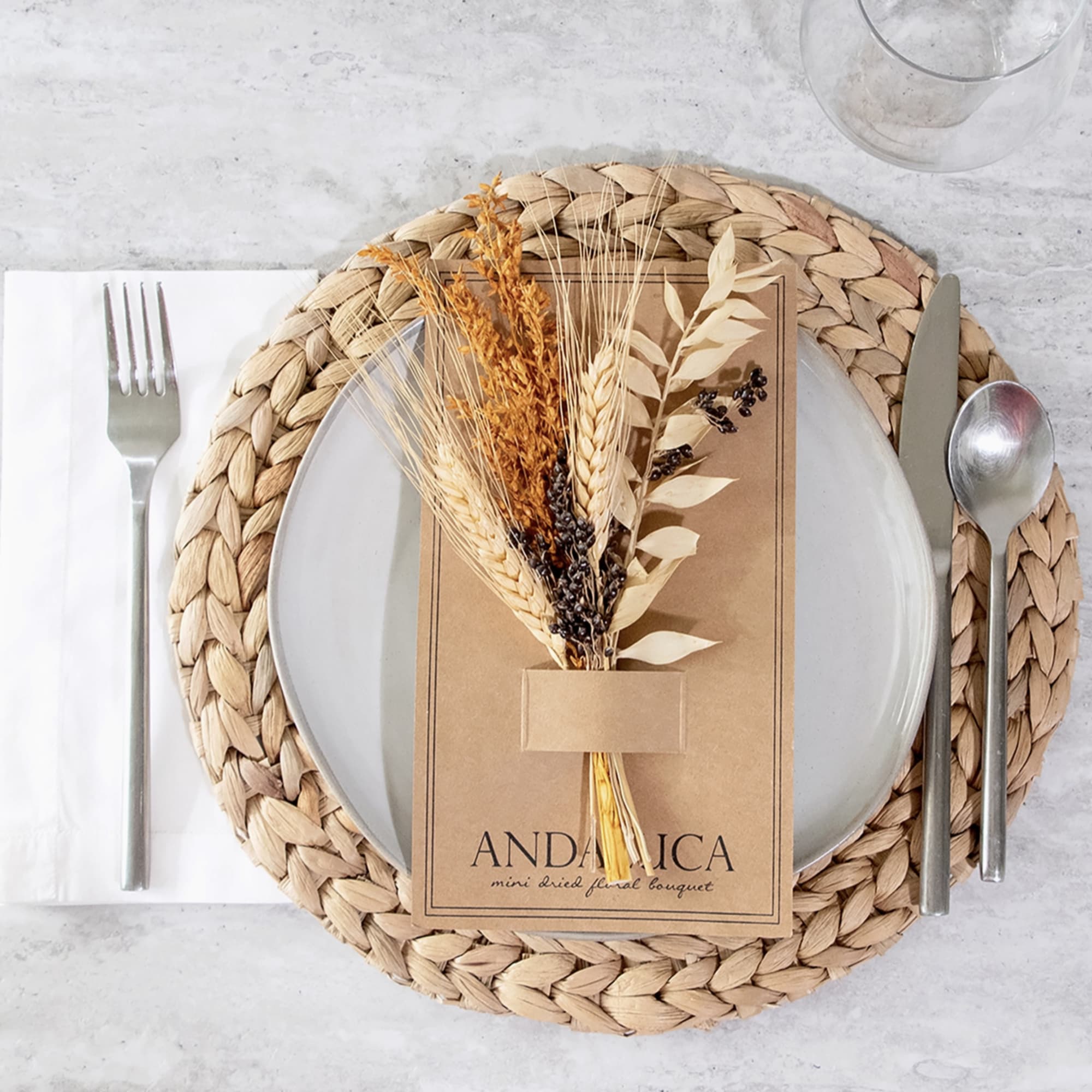 Mini dried floral bouquet in kraft packaging on a table setting