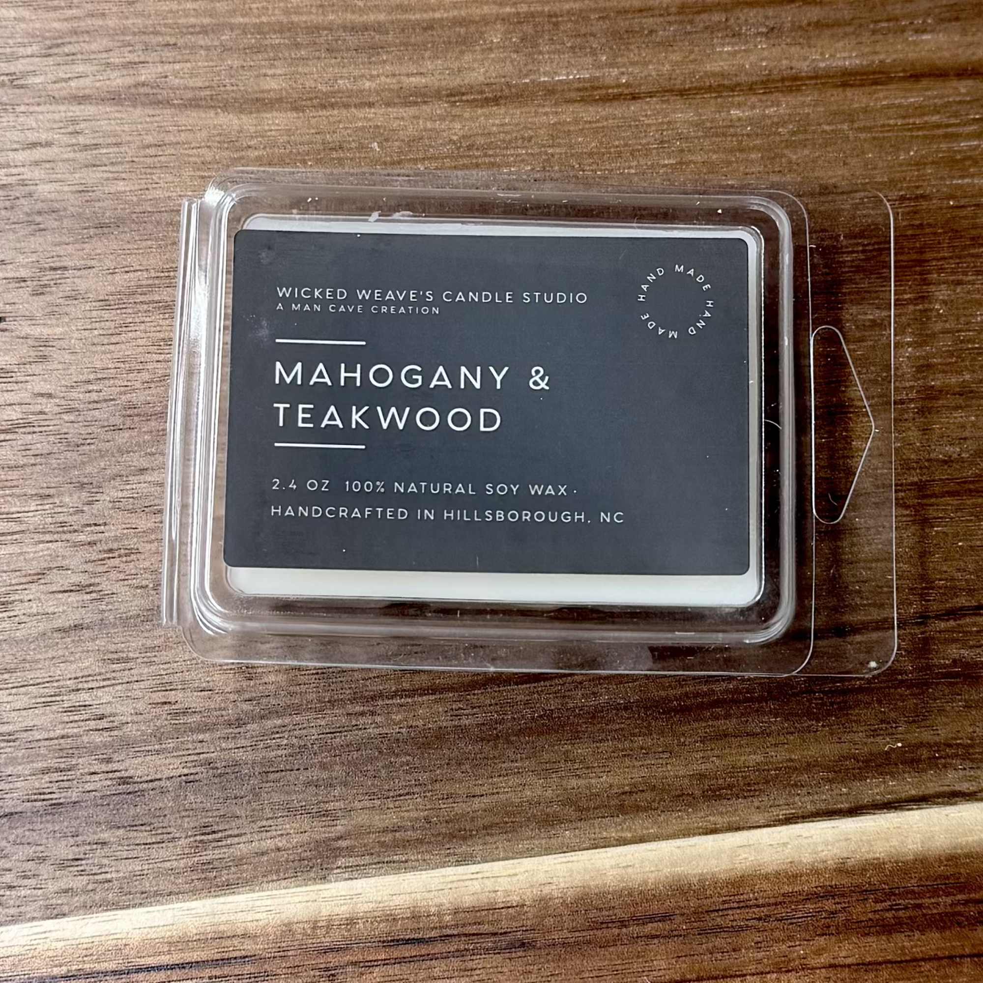 Mahogany and teakwood candle in a clear plastic clamshell
