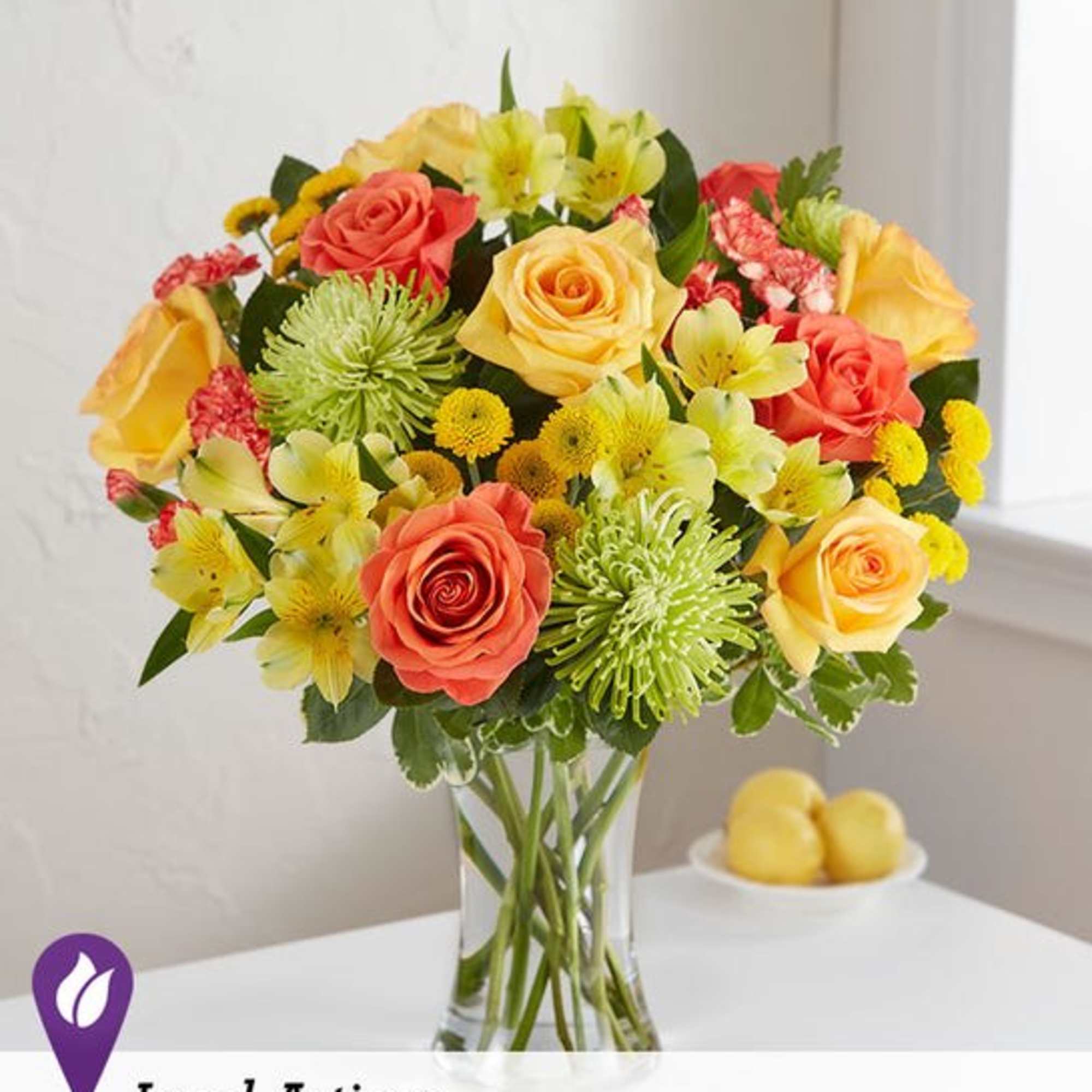 Mixed bouquet of roses and yellow flowers in a clear glass vase