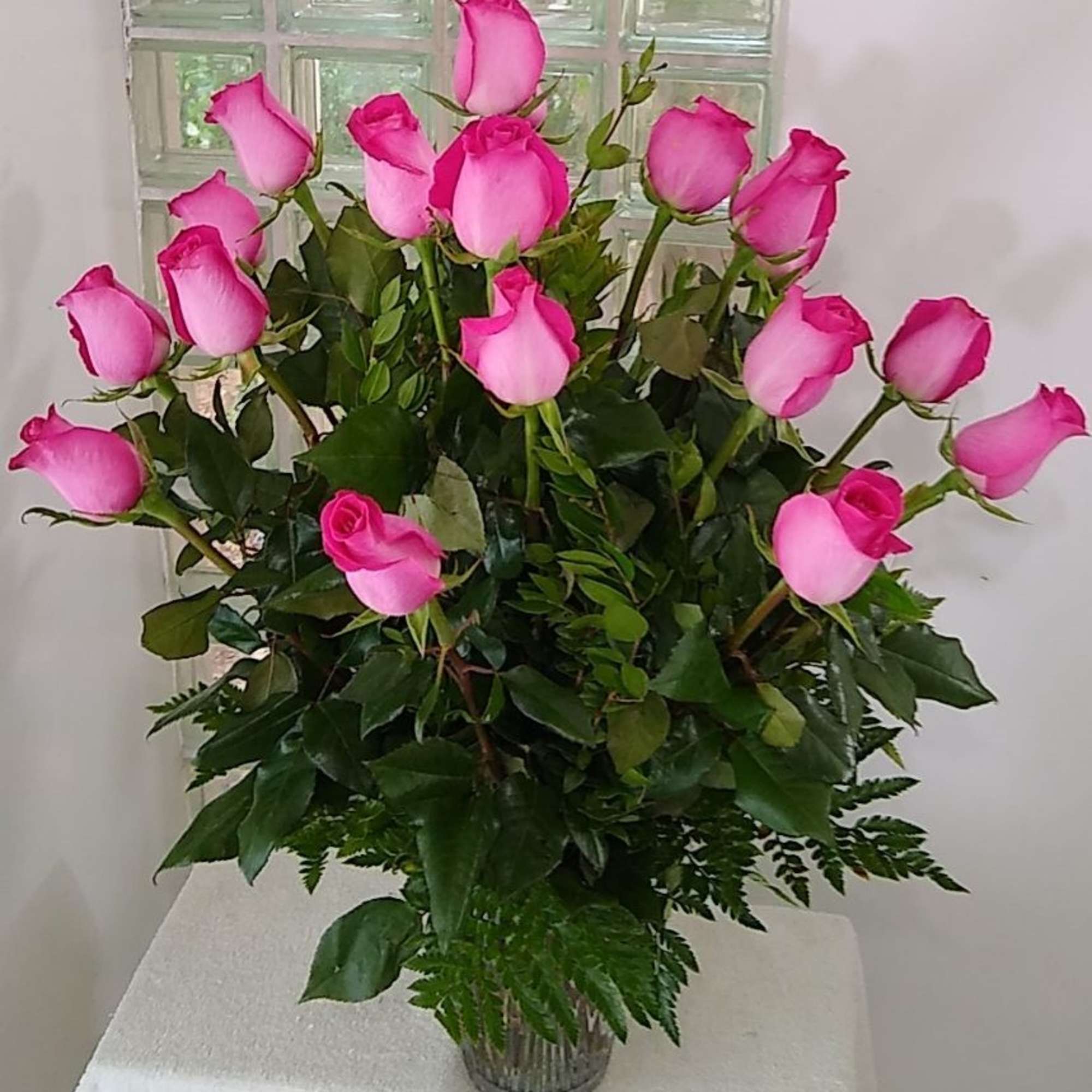 Pink roses arranged in a clear glass vase