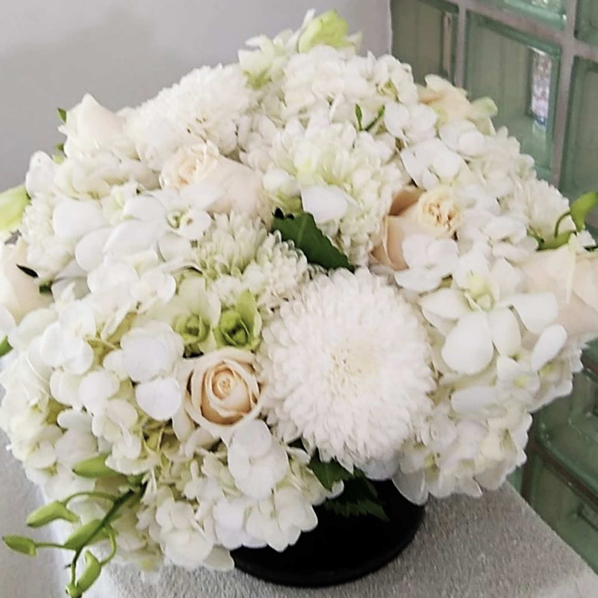 A plush cluster of mostly white blooms-big hydrangea heads cushioned by creamy