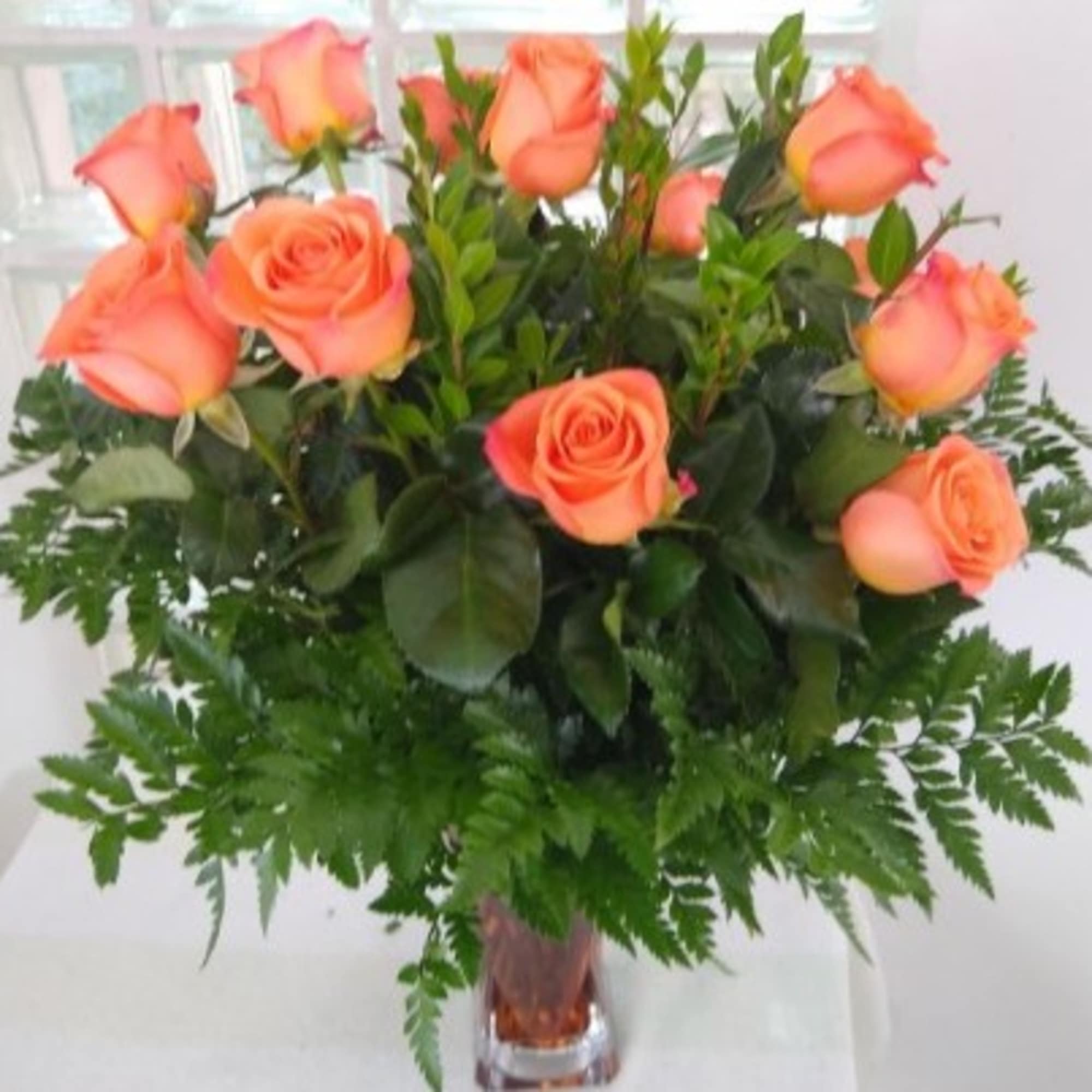 Peach roses arranged in a clear glass vase