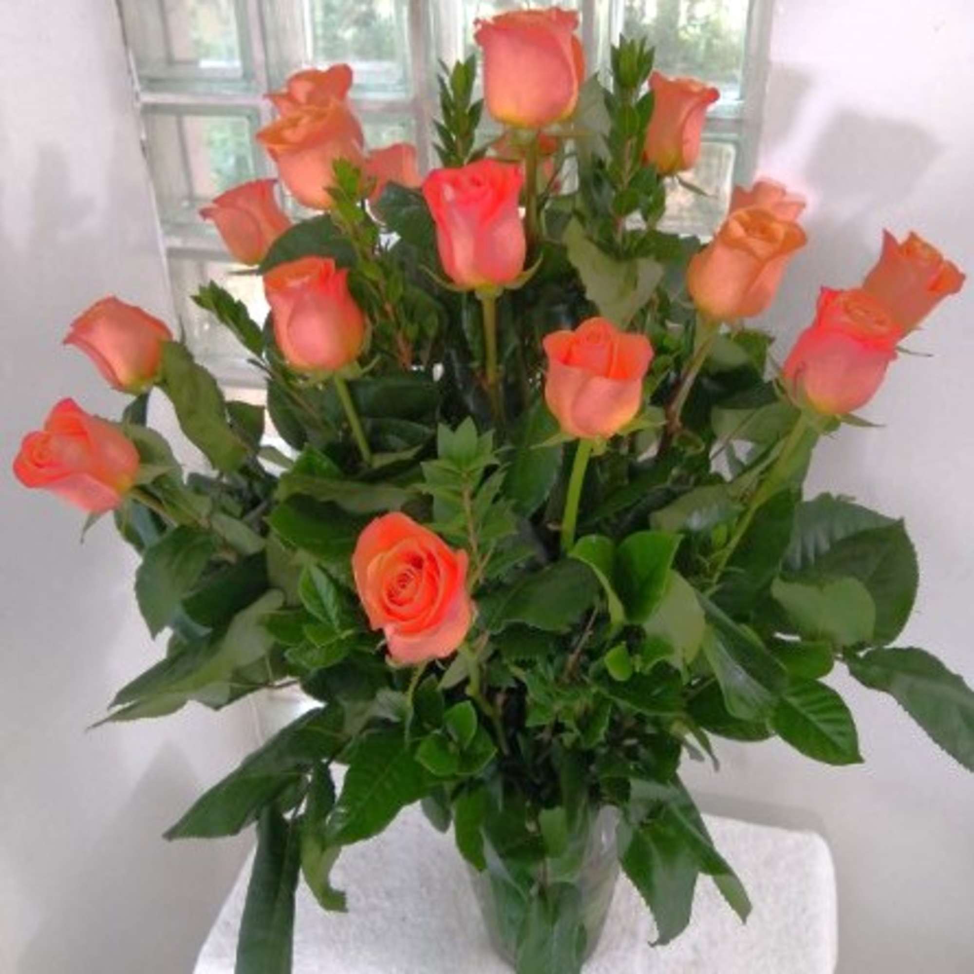 Orange roses arranged in a clear glass vase