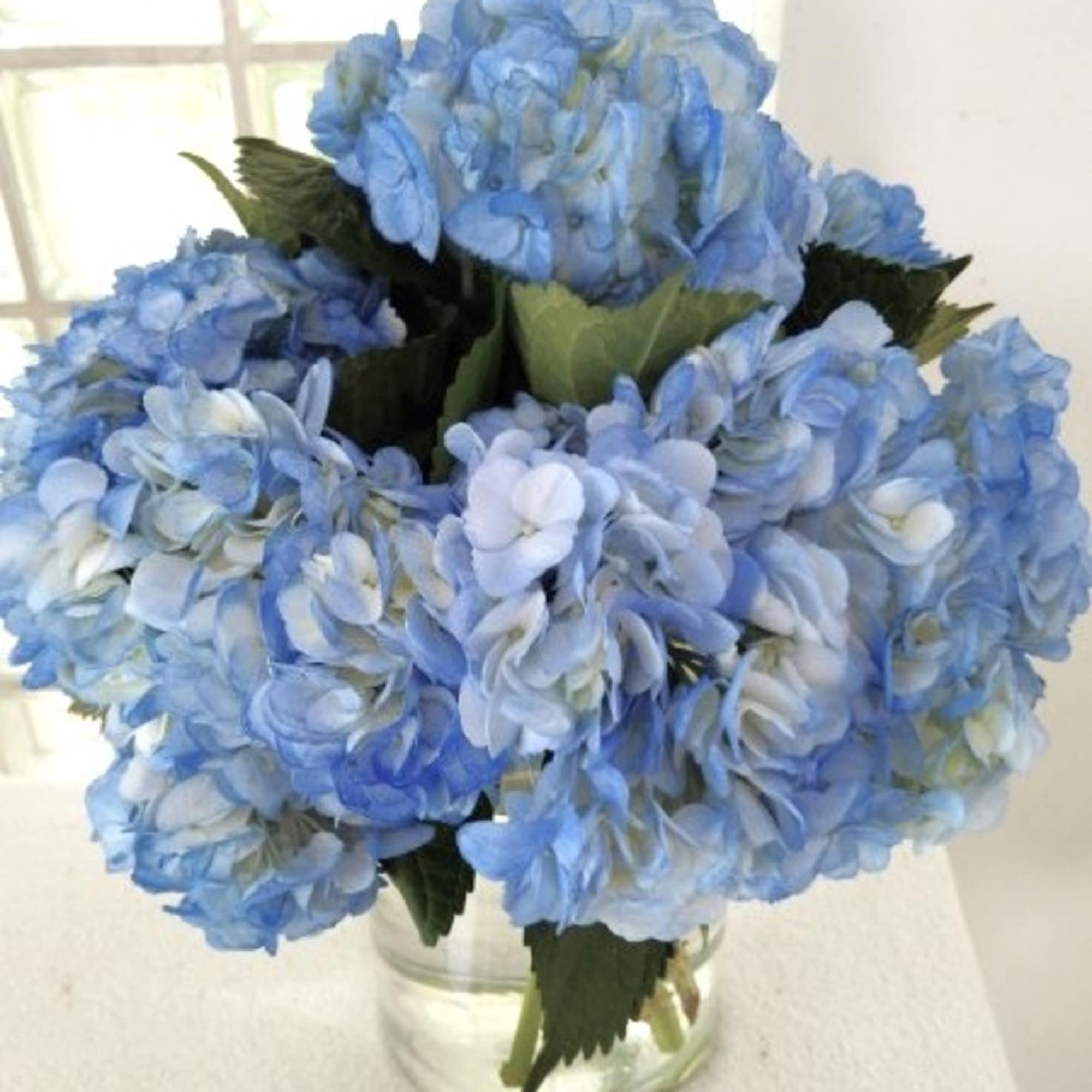 Blue hydrangea bouquet in a clear glass vase