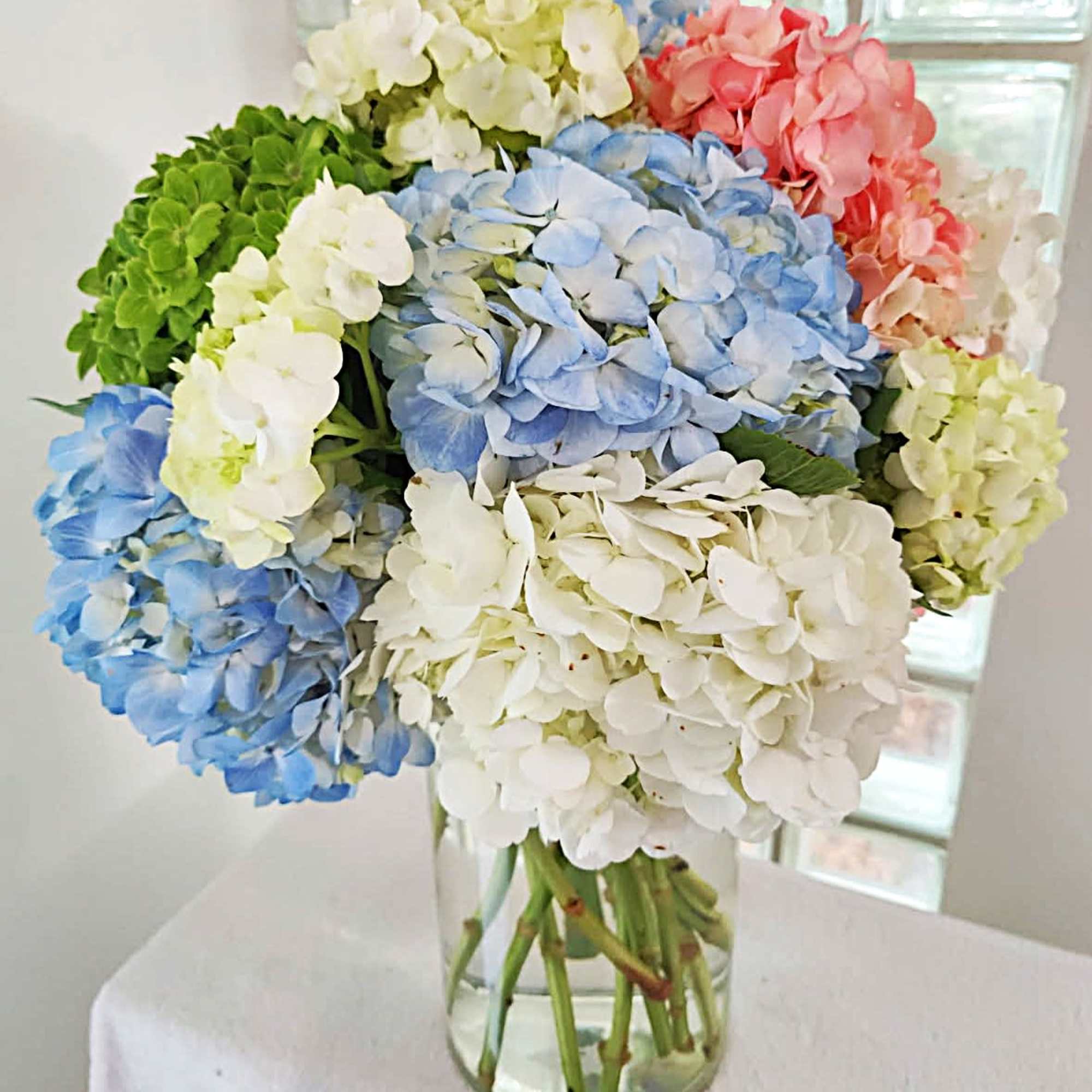 Bouquet of multicolored hydrangeas in a clear glass vase