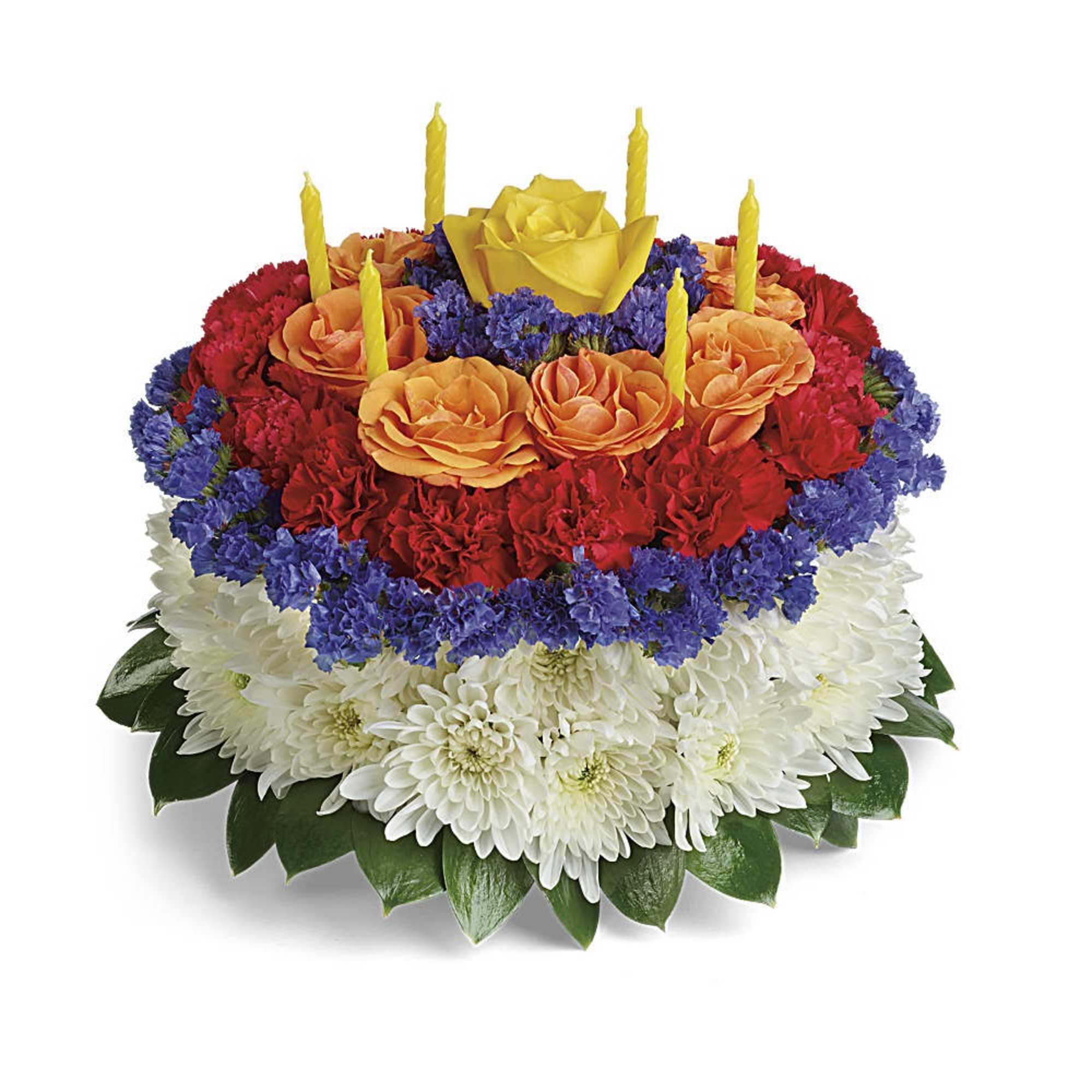 Round floral cake of white mums, red carnations, orange and yellow roses with yellow candles