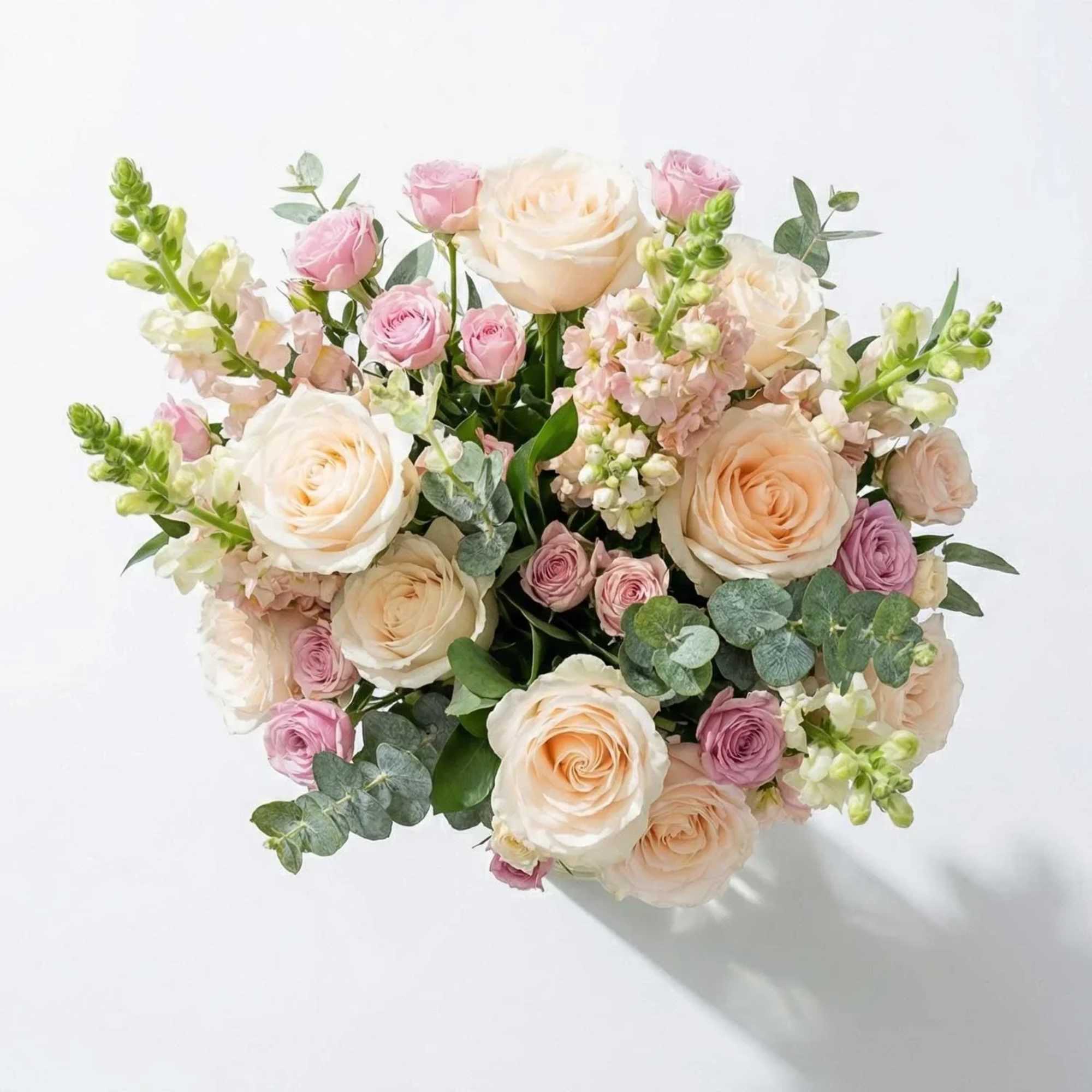 The expertly curated luxury bouquet features a lush bed of textural foliage.