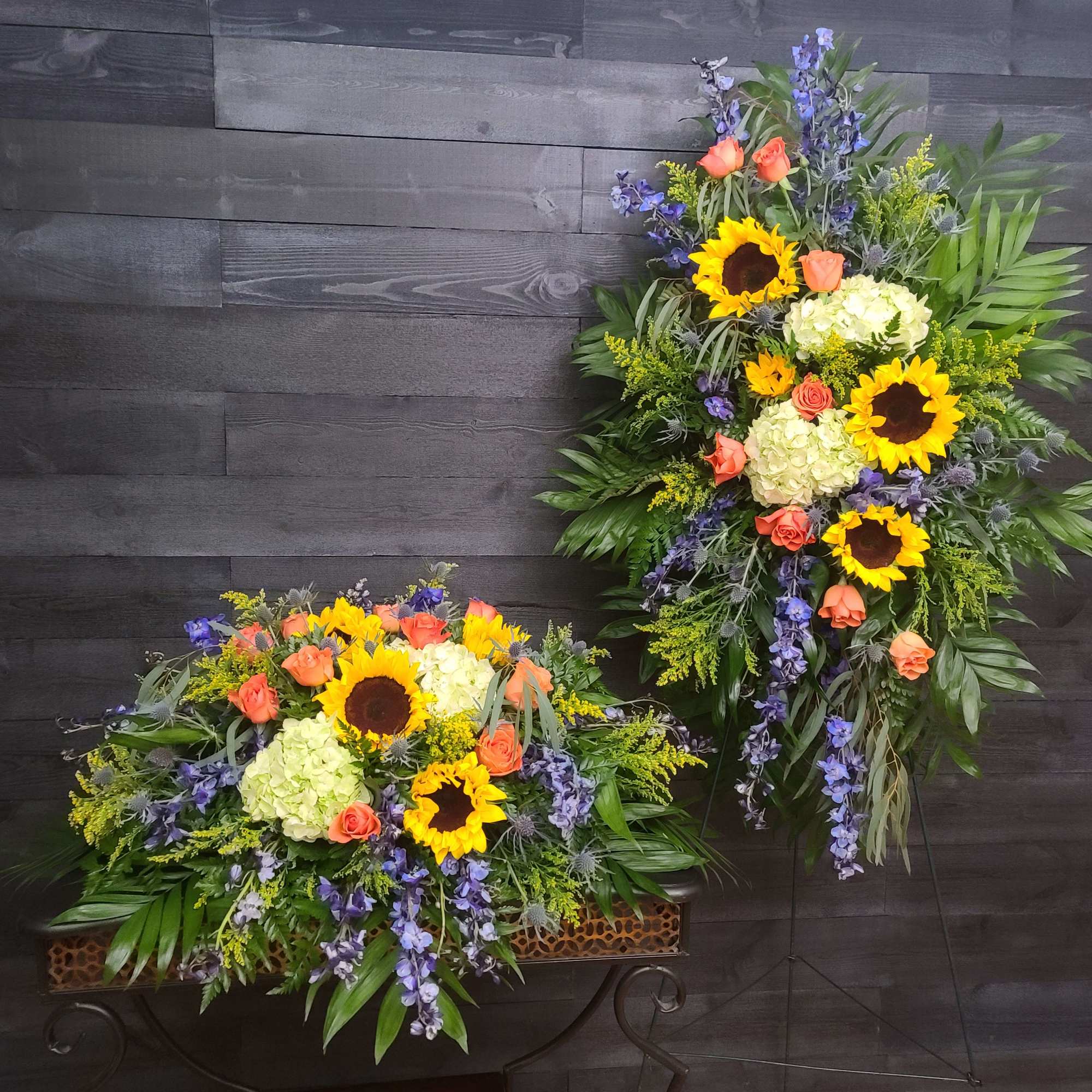 Two large floral sprays with sunflowers, roses, and hydrangeas on stands