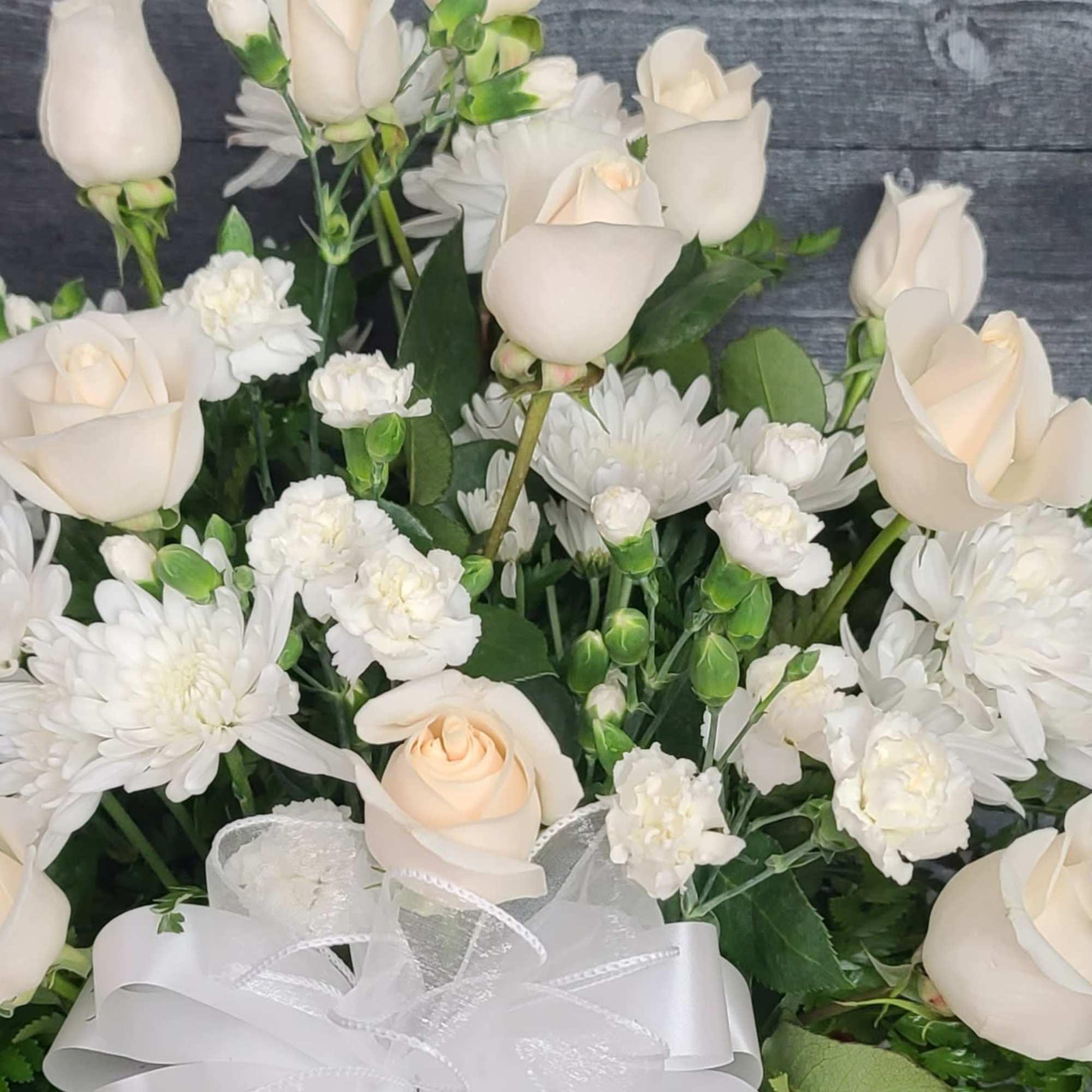 White roses and chrysanthemums arranged with a sheer ribbon