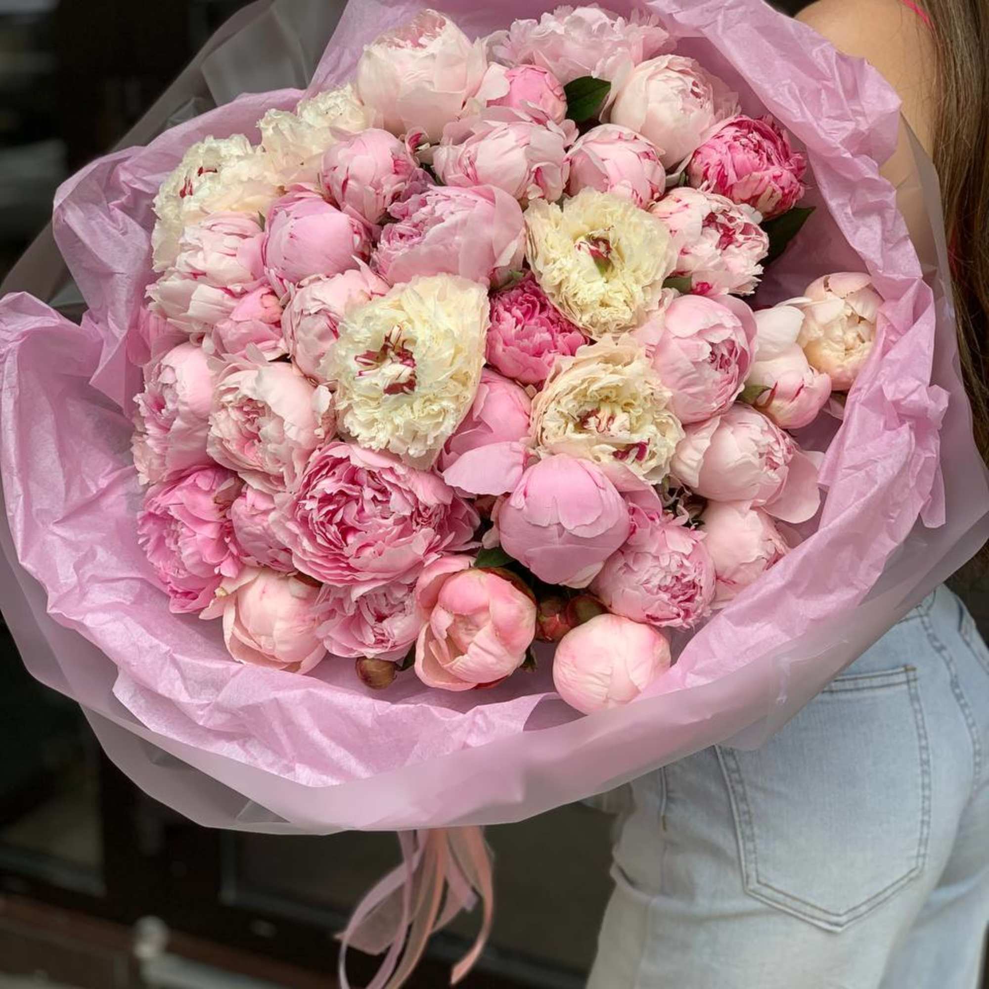 Large bouquet of pink peonies wrapped in pink paper