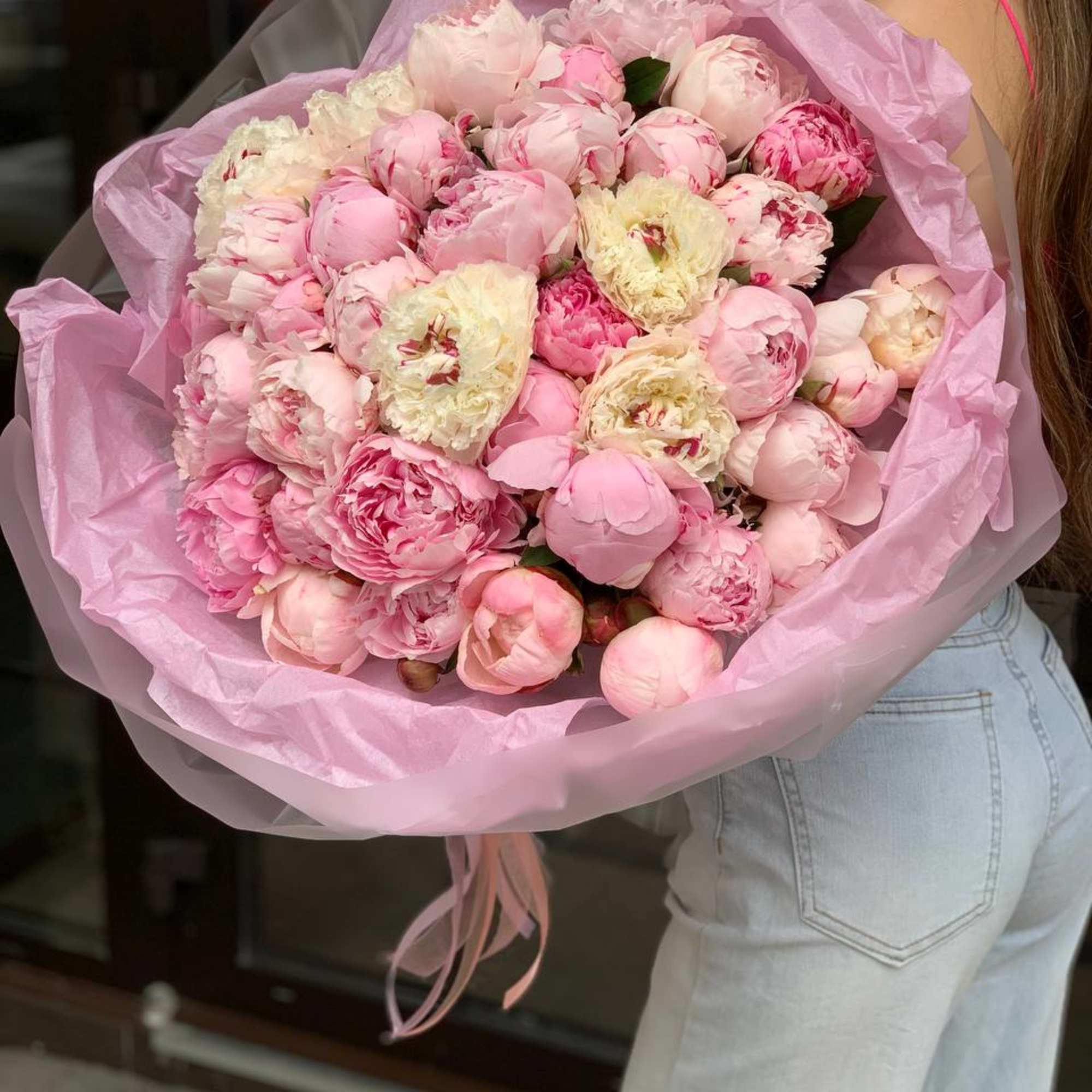 Large bouquet of pink peonies wrapped in pink paper