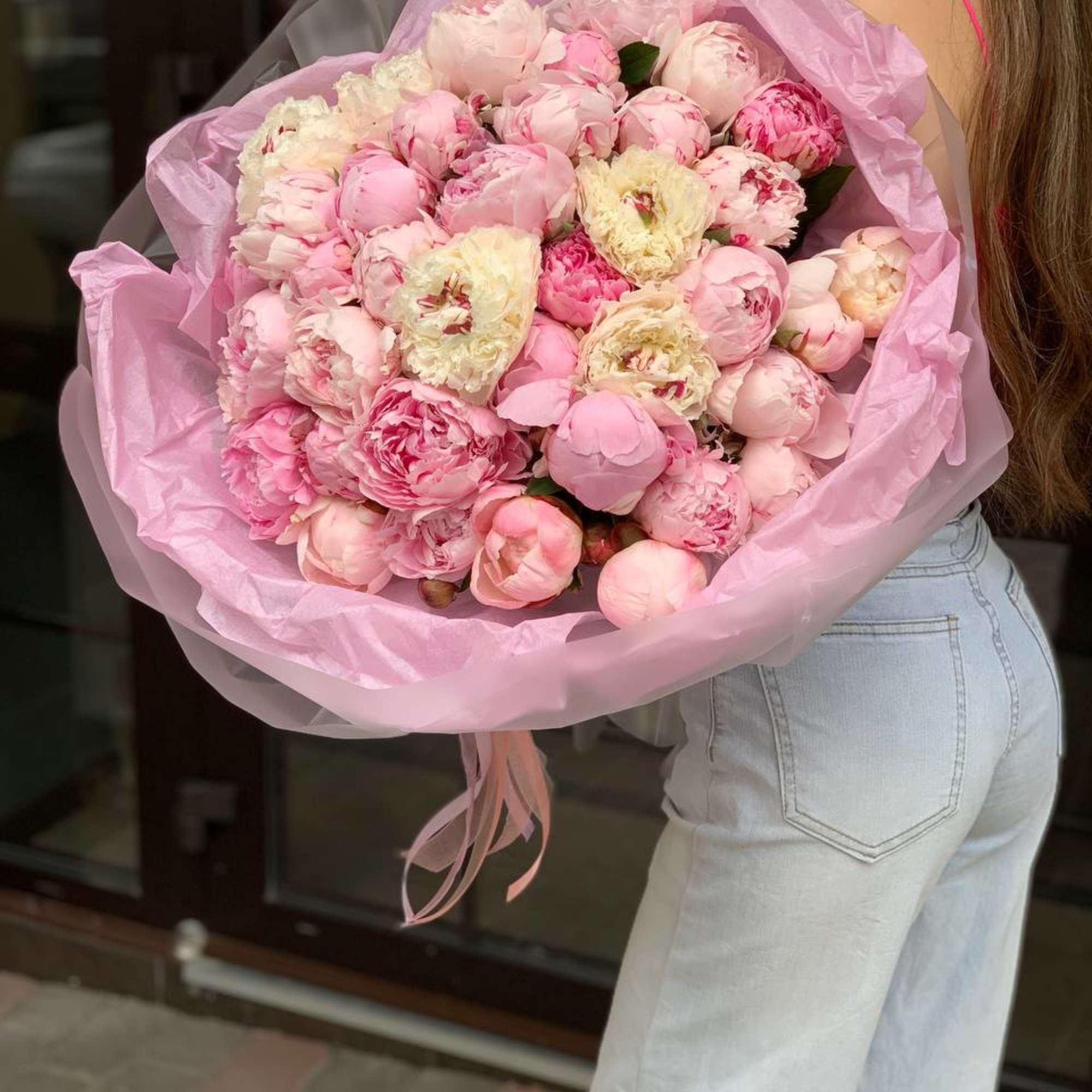 Large bouquet of pink and cream peonies wrapped in pink paper