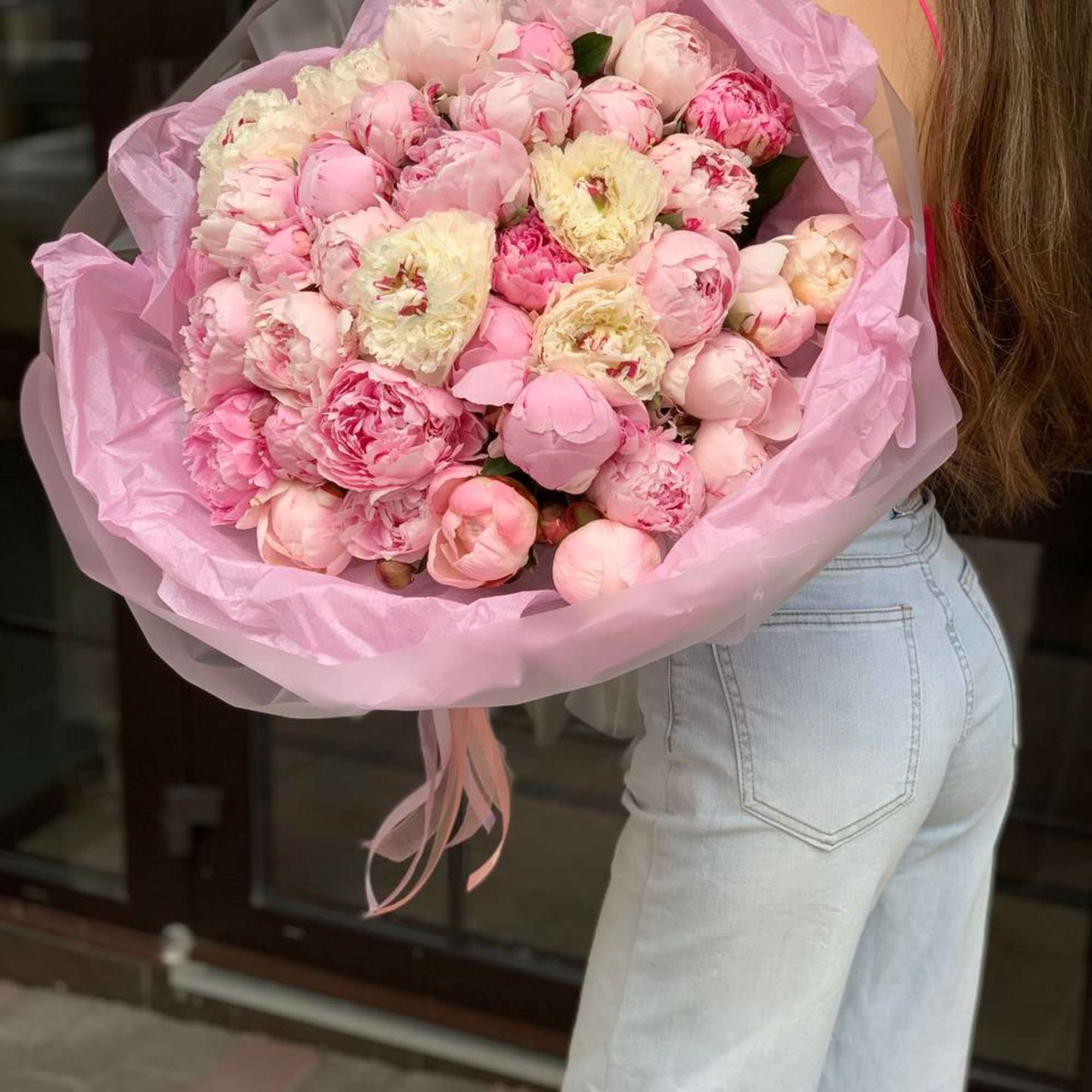 Large bouquet of pink and cream peonies wrapped in pink paper