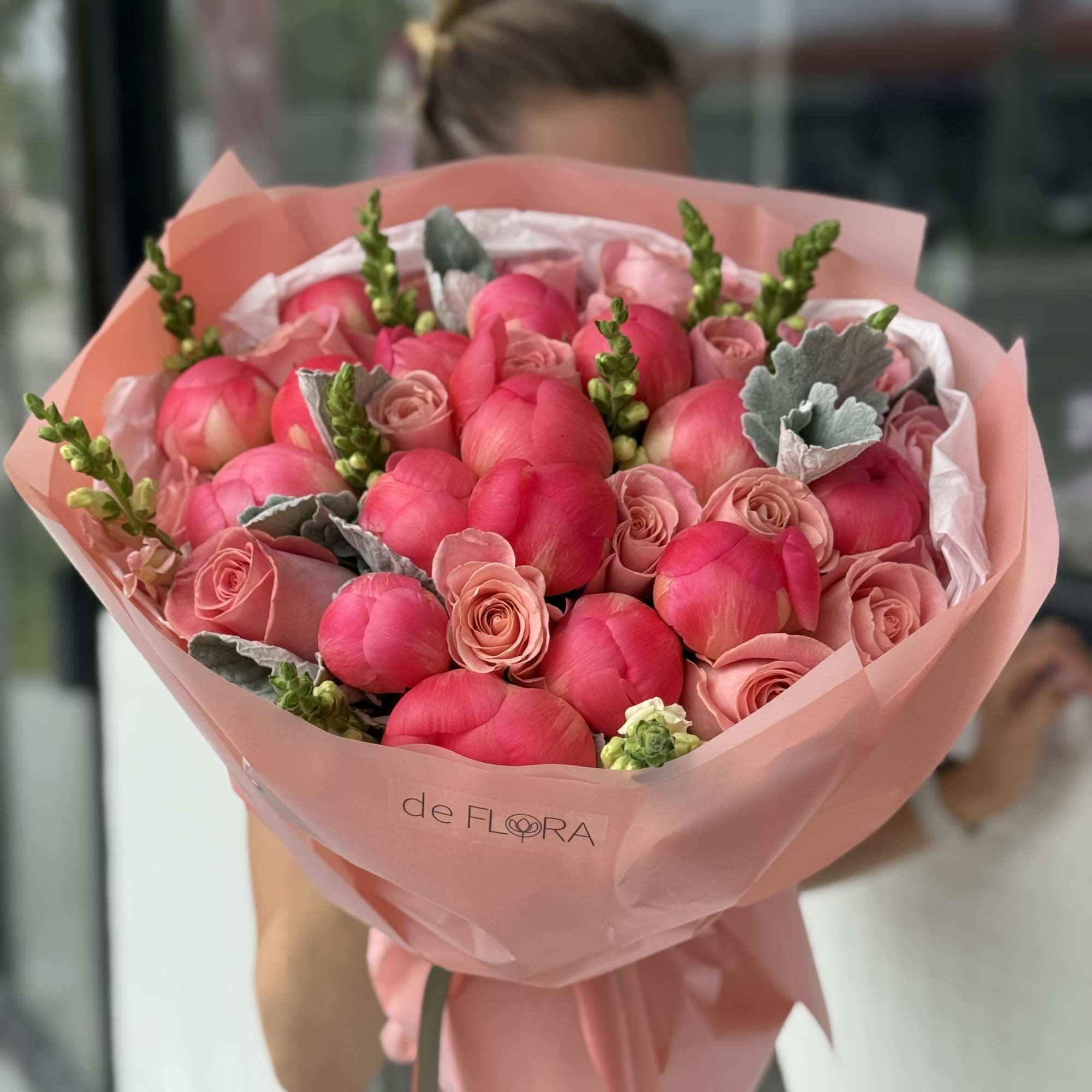 Pink bouquet of roses and tulips wrapped in blush paper