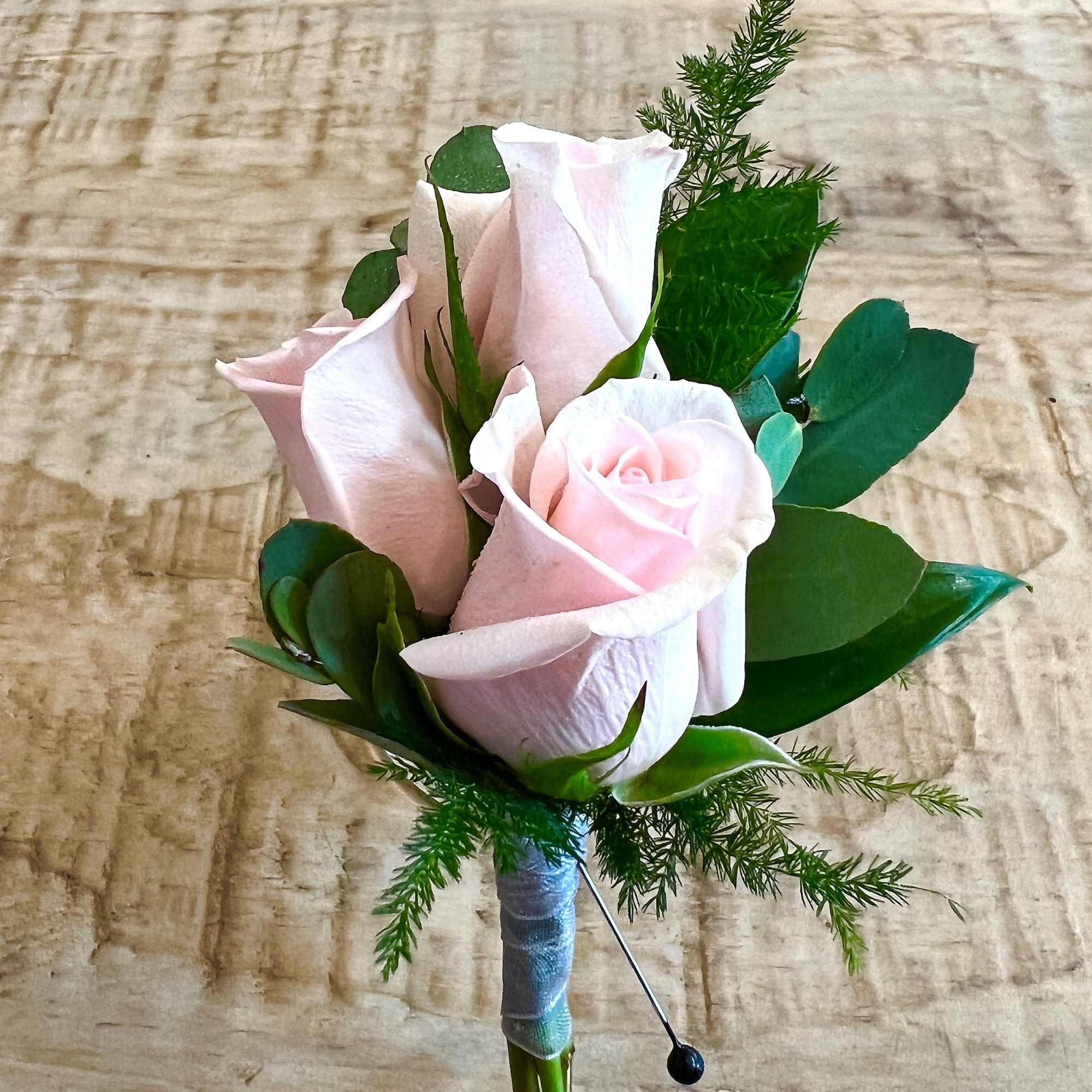 Boutonniere with pale pink roses and greenery