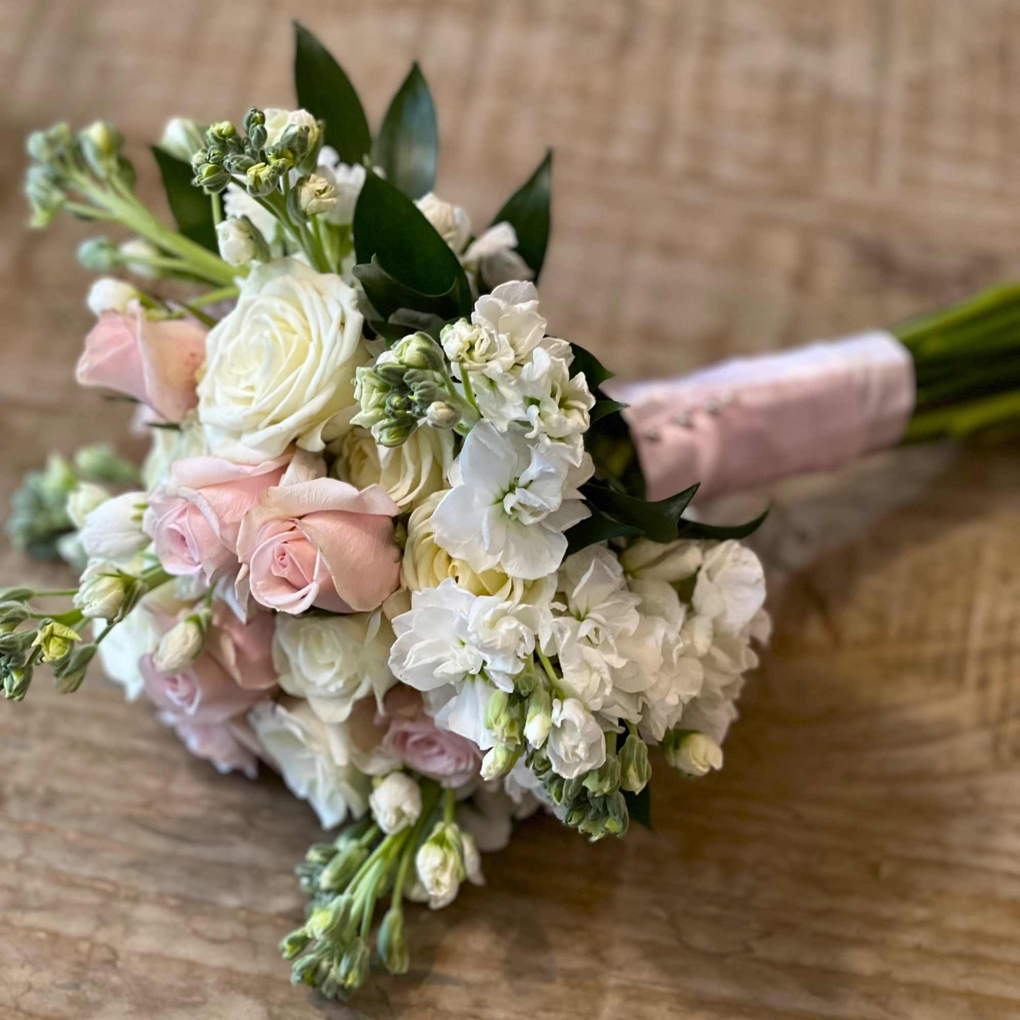 Hand-tied bouquet of white and pale pink roses with white blooms