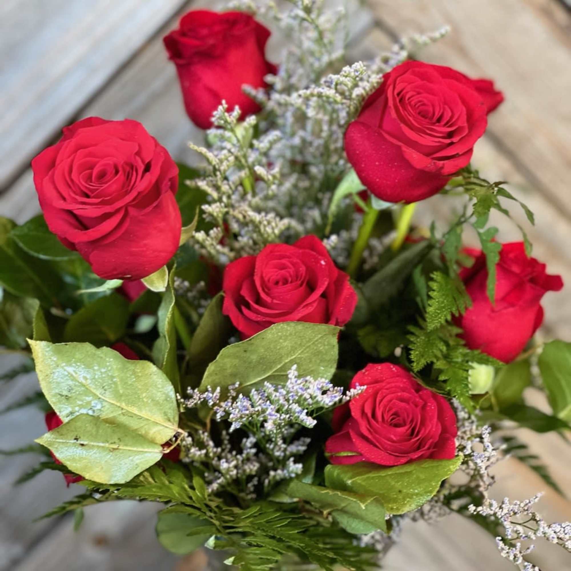 Bouquet of red roses with filler in a glass vase