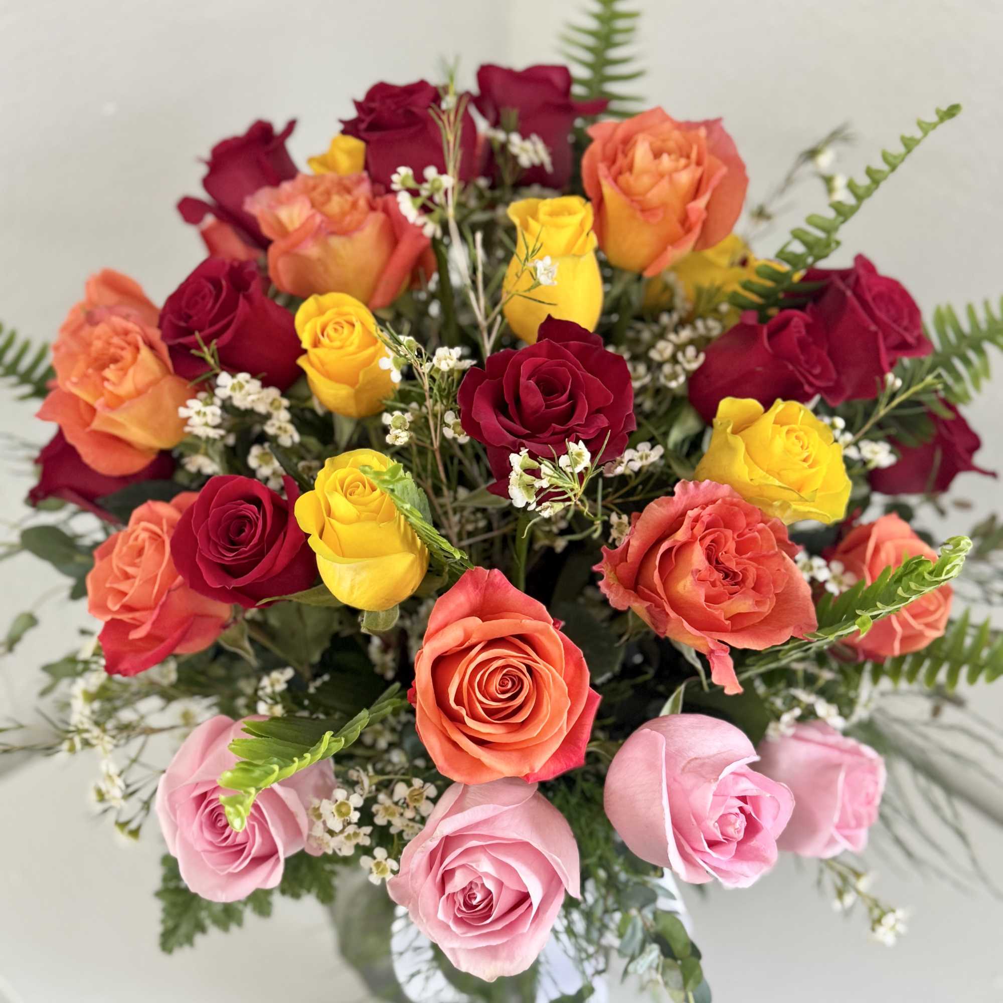 Bouquet of multicolored roses with small white filler flowers
