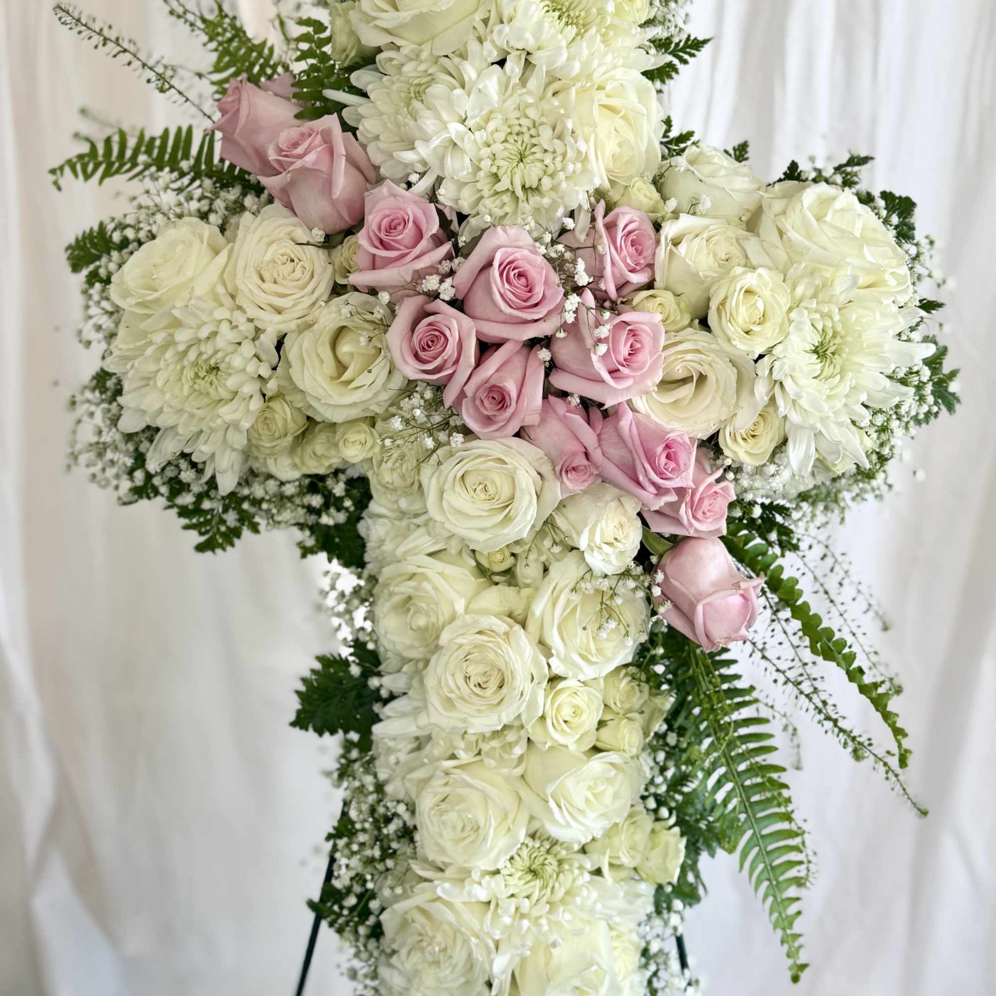 Cross-shaped floral spray with white and pink roses