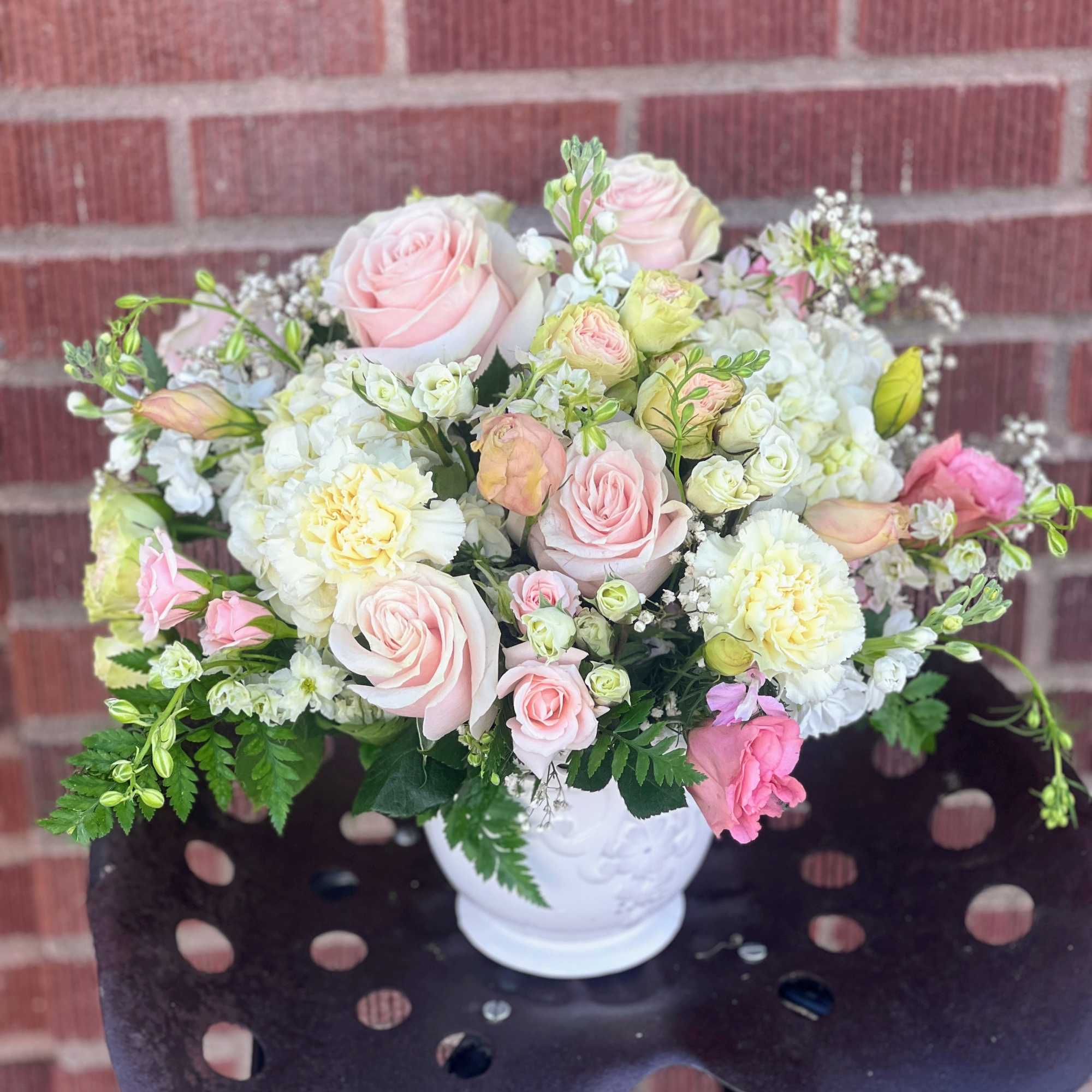 Pink and white rose bouquet in a white vase