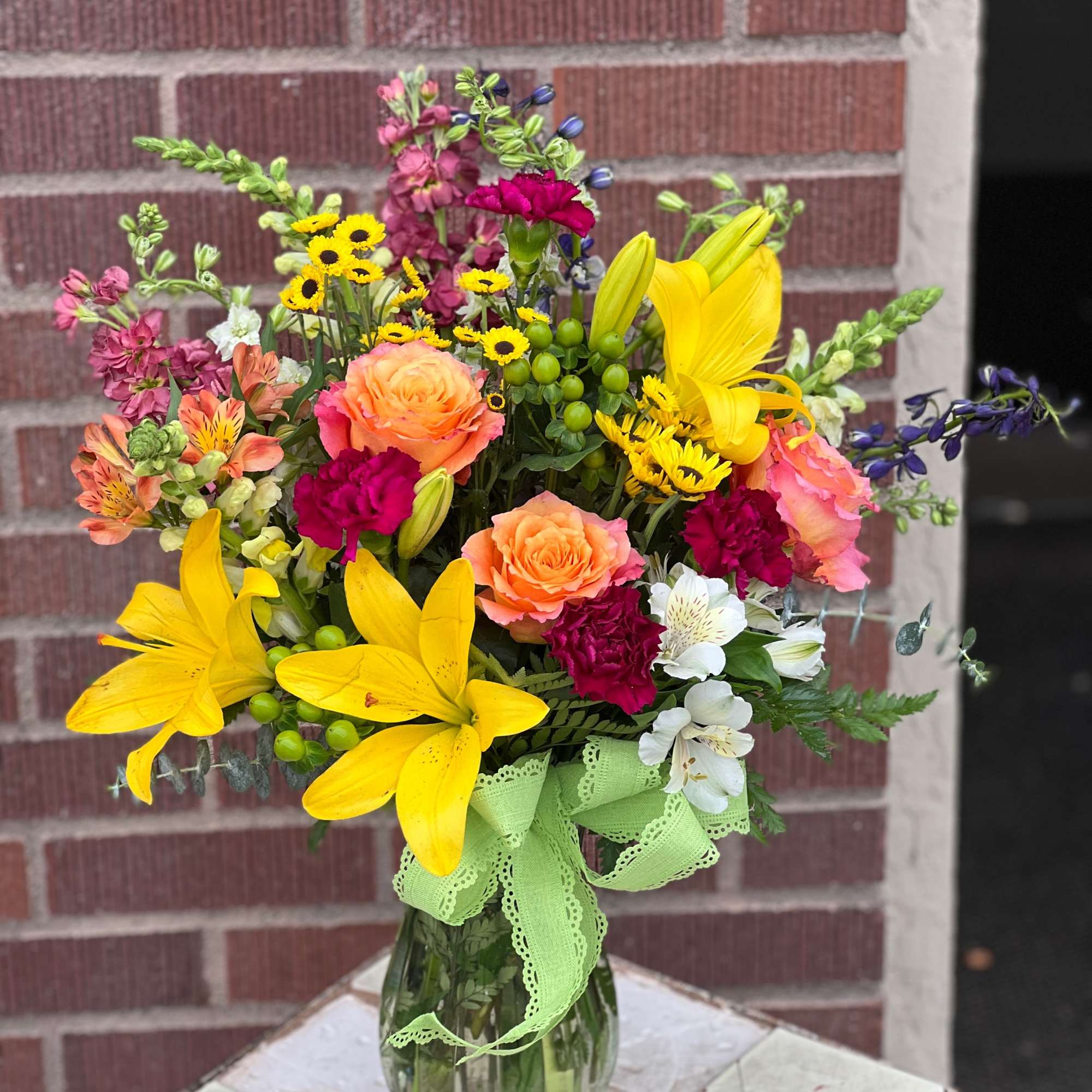 Colorful bouquet of lilies, roses, and mixed blooms in a glass vase