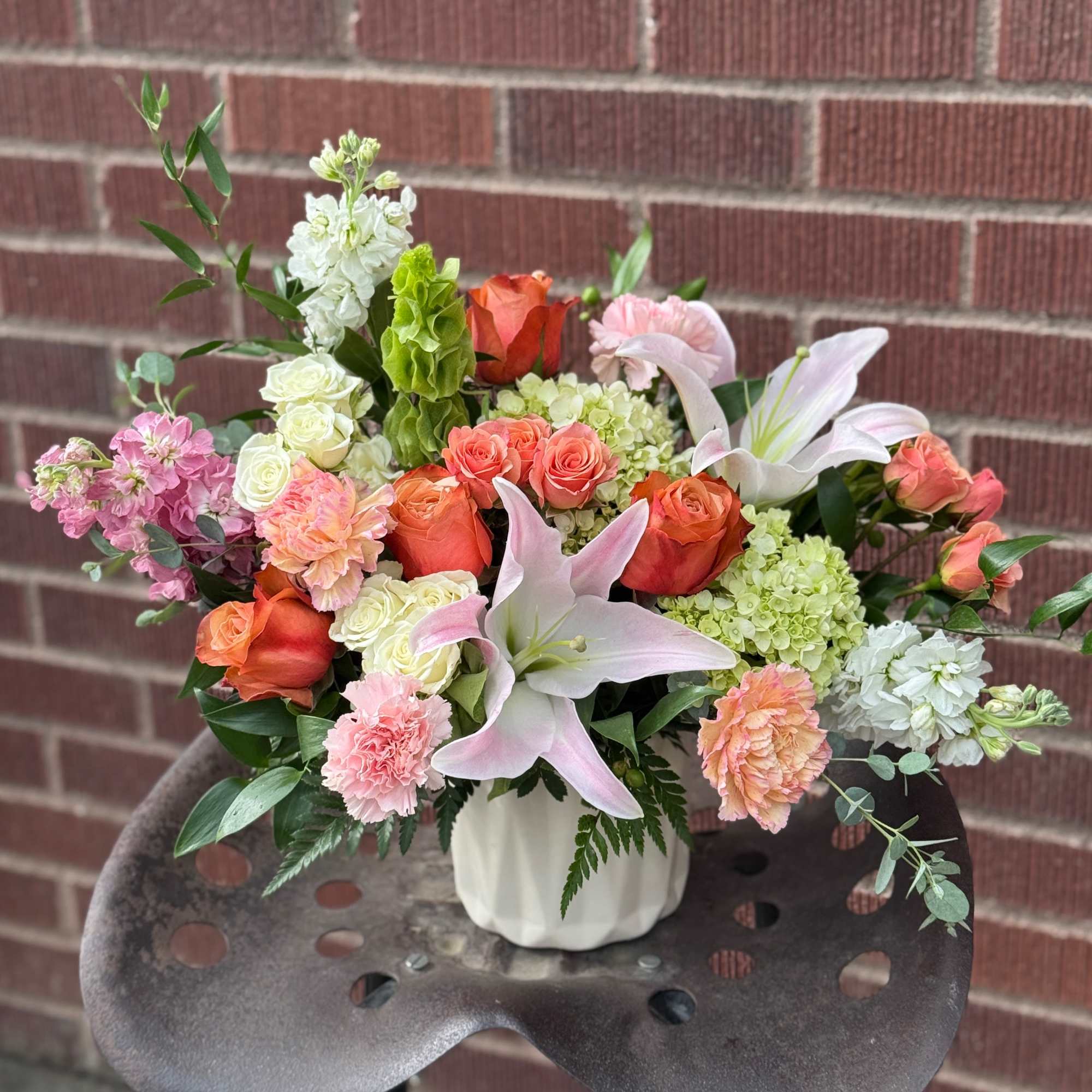 Mixed bouquet in a white vase with pink lilies and roses