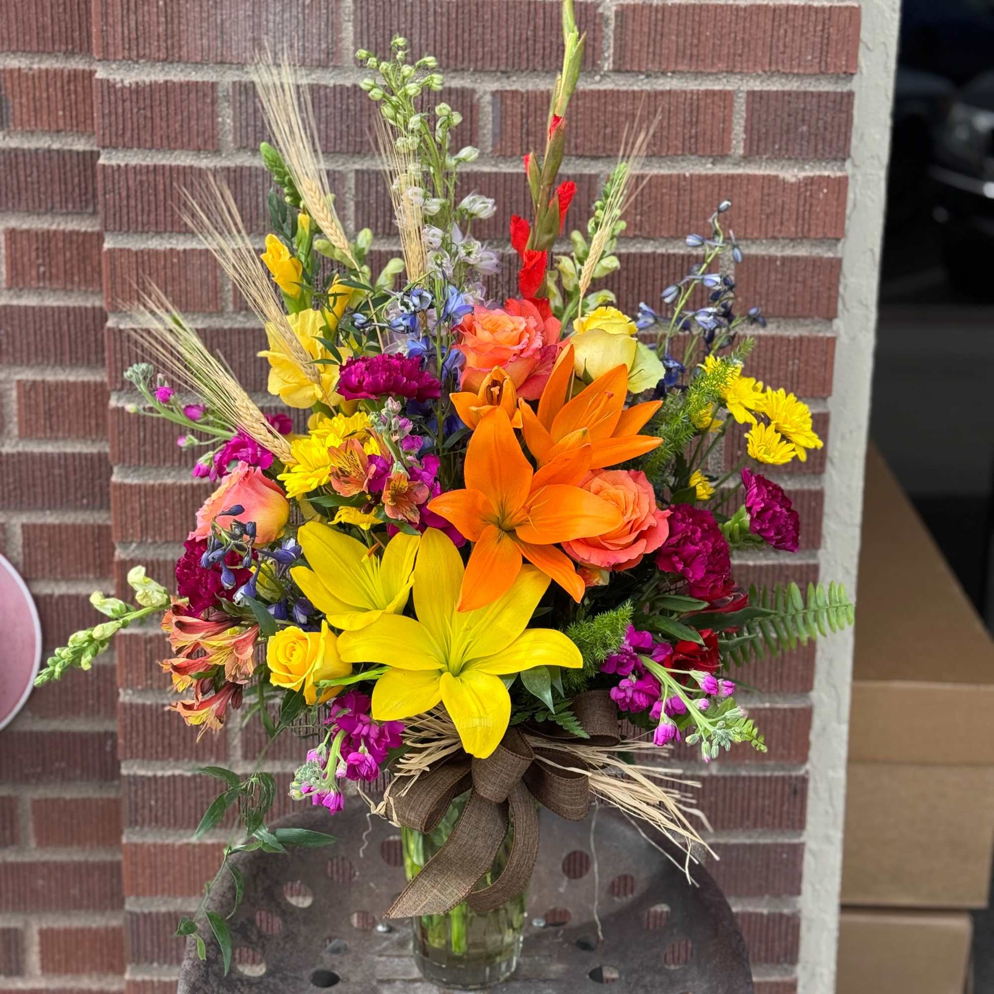 Bright mixed bouquet with lilies, roses, and daisies in a glass vase